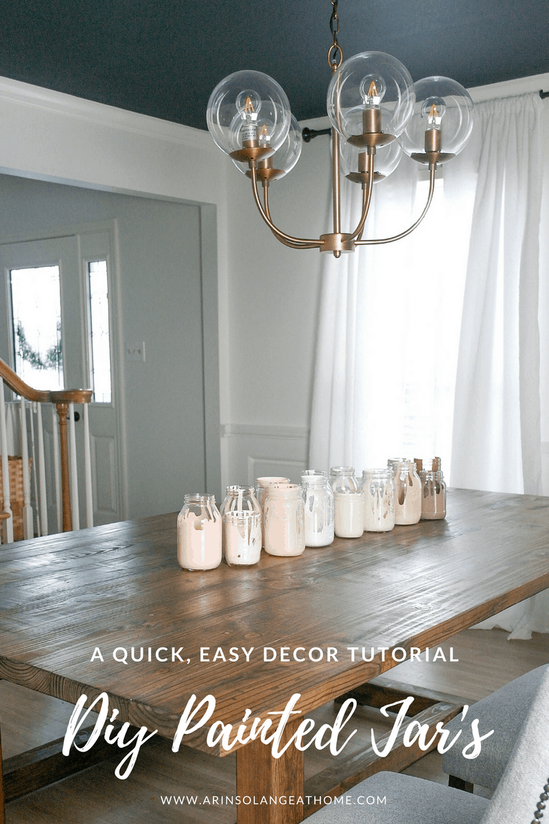 white room with wood table and painted mason jars