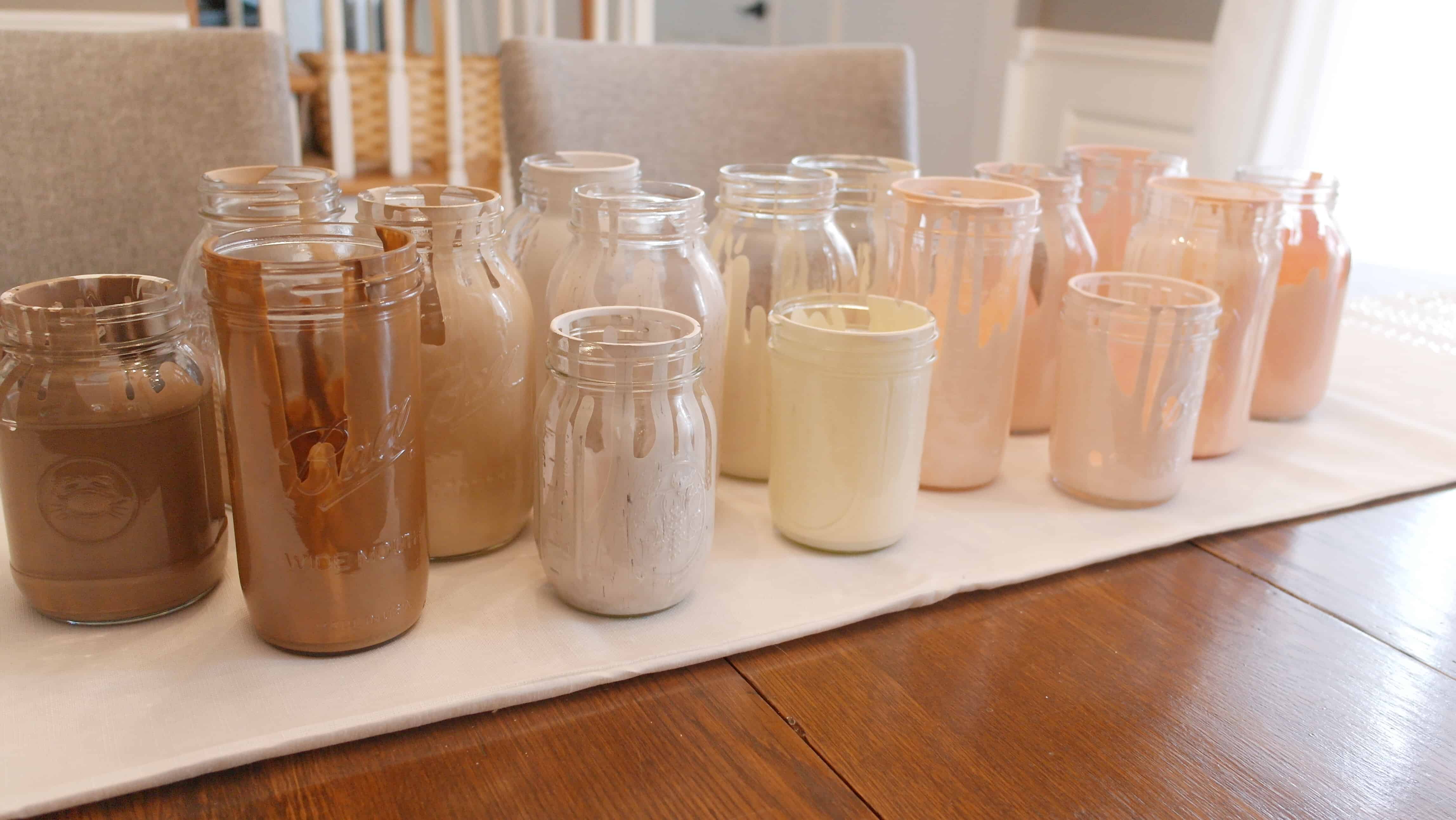 painted jars on white table runner on table