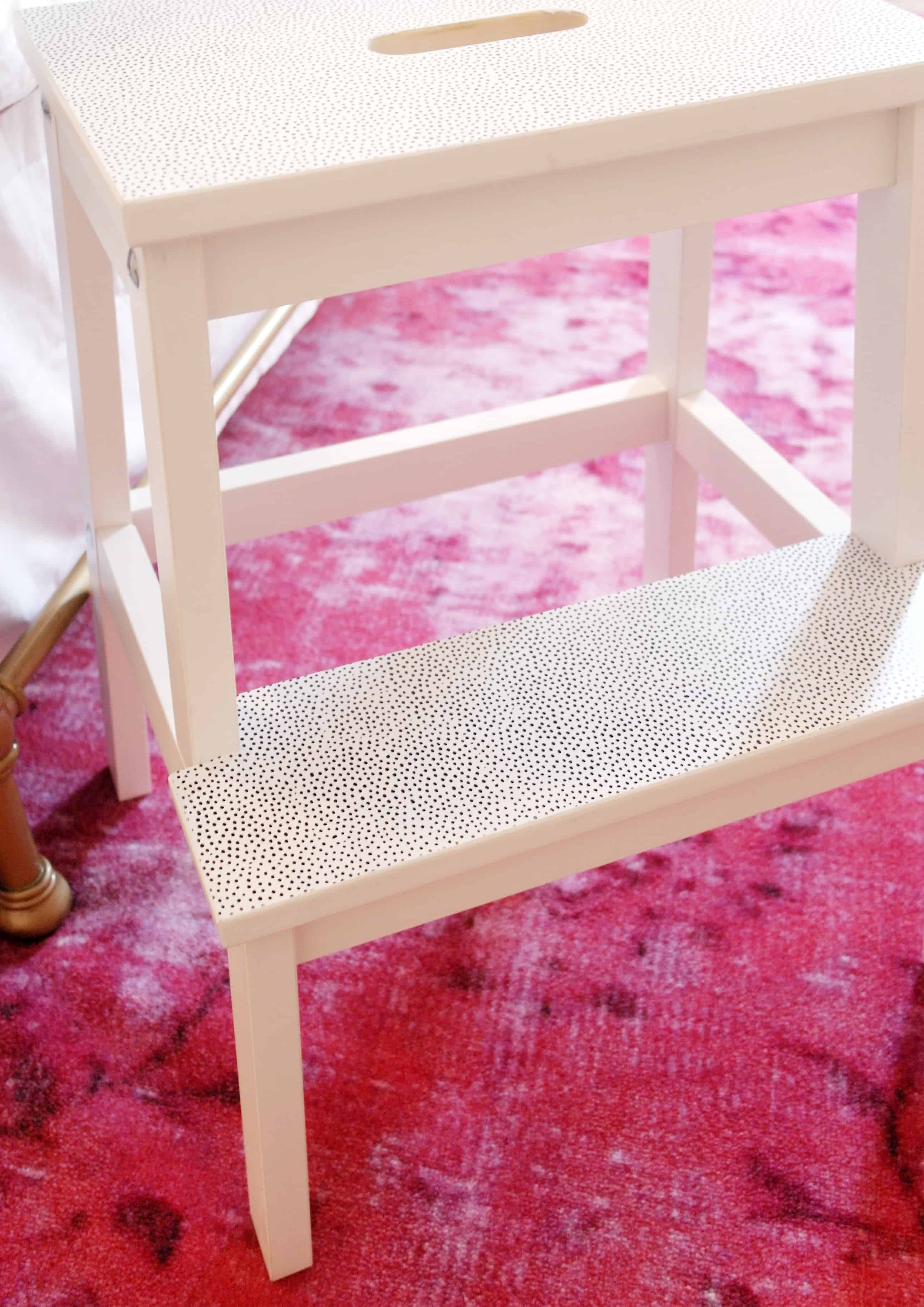 white stool on pink rug
