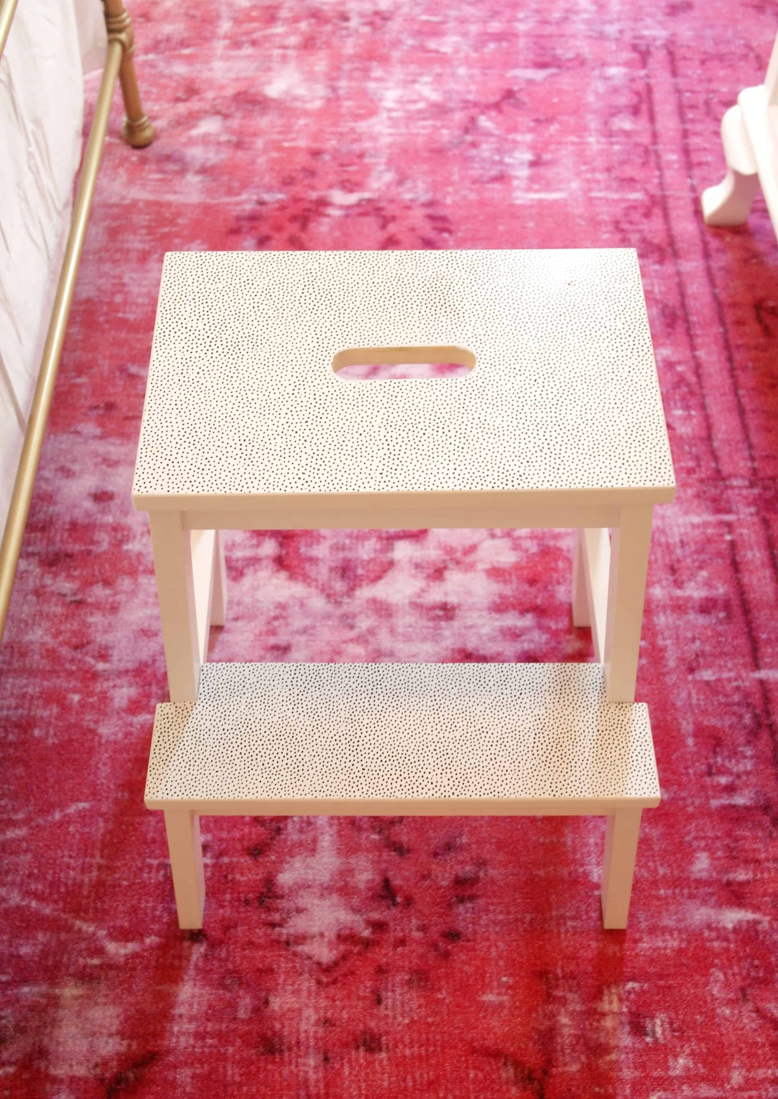 white stool on pink rug