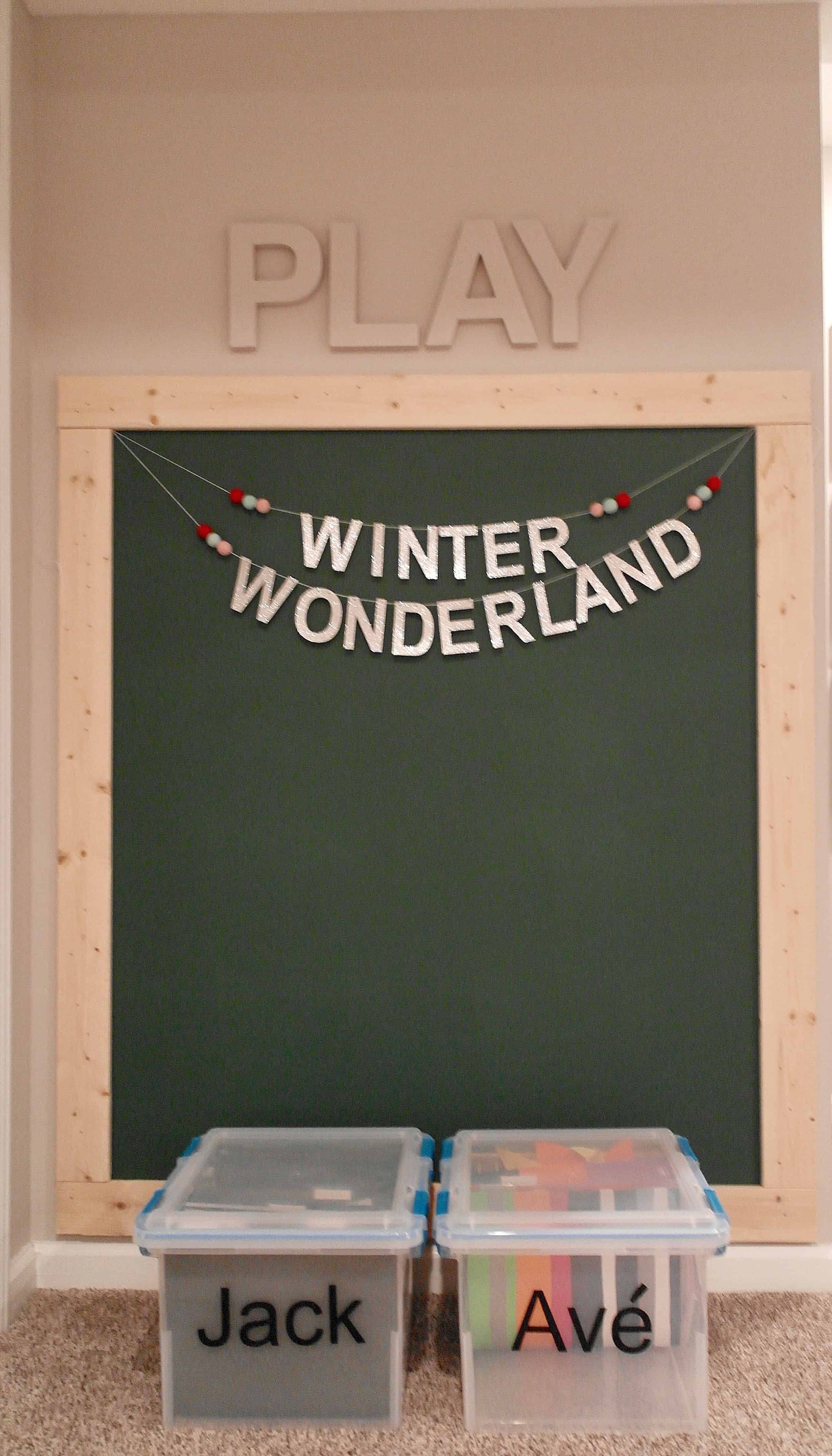 large chalkboard wall with bins for kids artwork