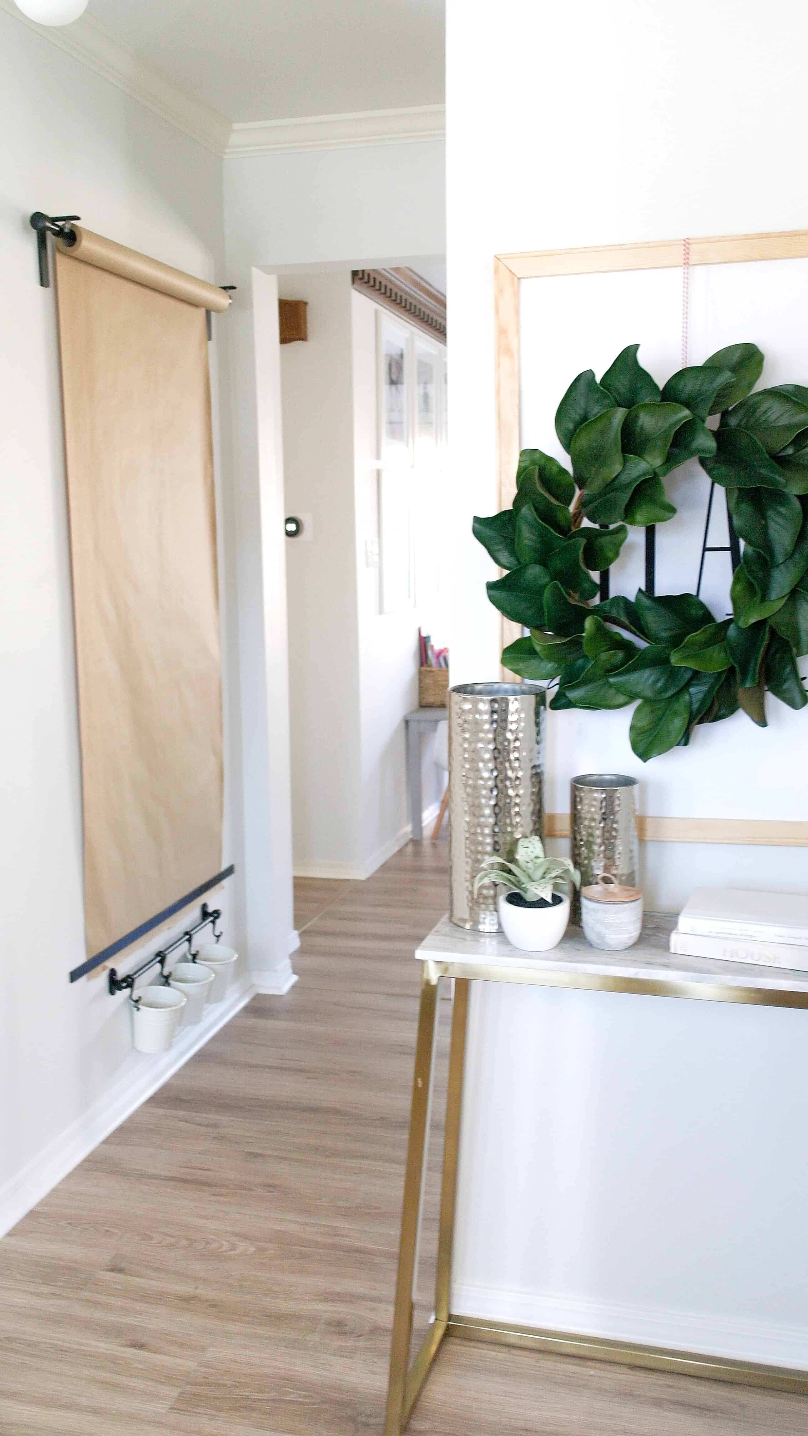 Entry way table with wreath and wall mounted paper roll and bins. Lifestyle blogger Arin Solange shares an Ikea Hack, how to create the perfect DIY Wall mounted Easel. 