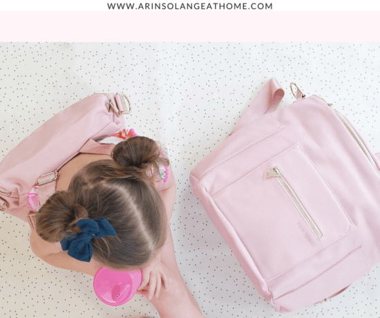little girl with pink fawn design bag and blush fawn design diaper bag