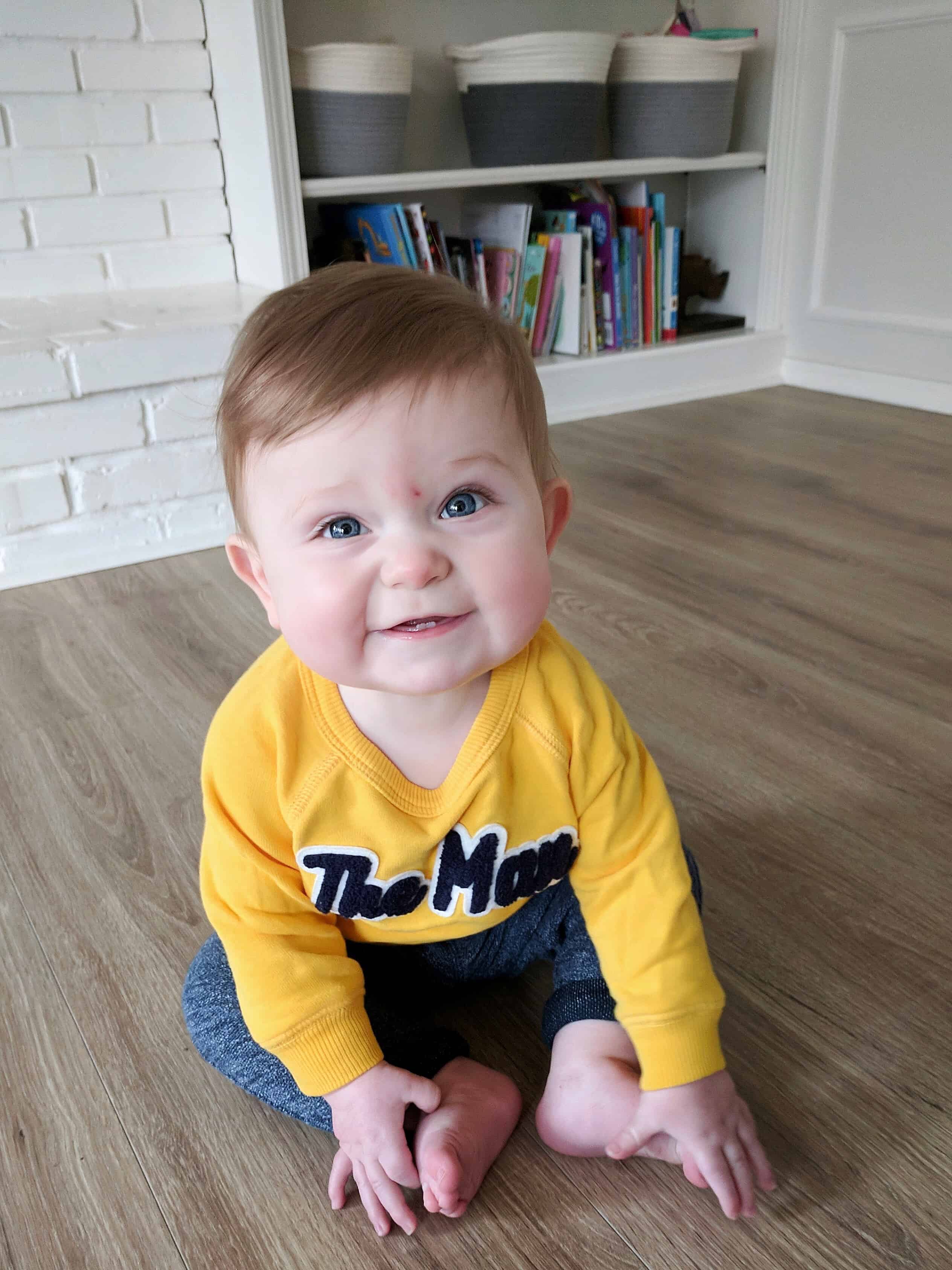 baby boy in yellow sweatshirt on couch