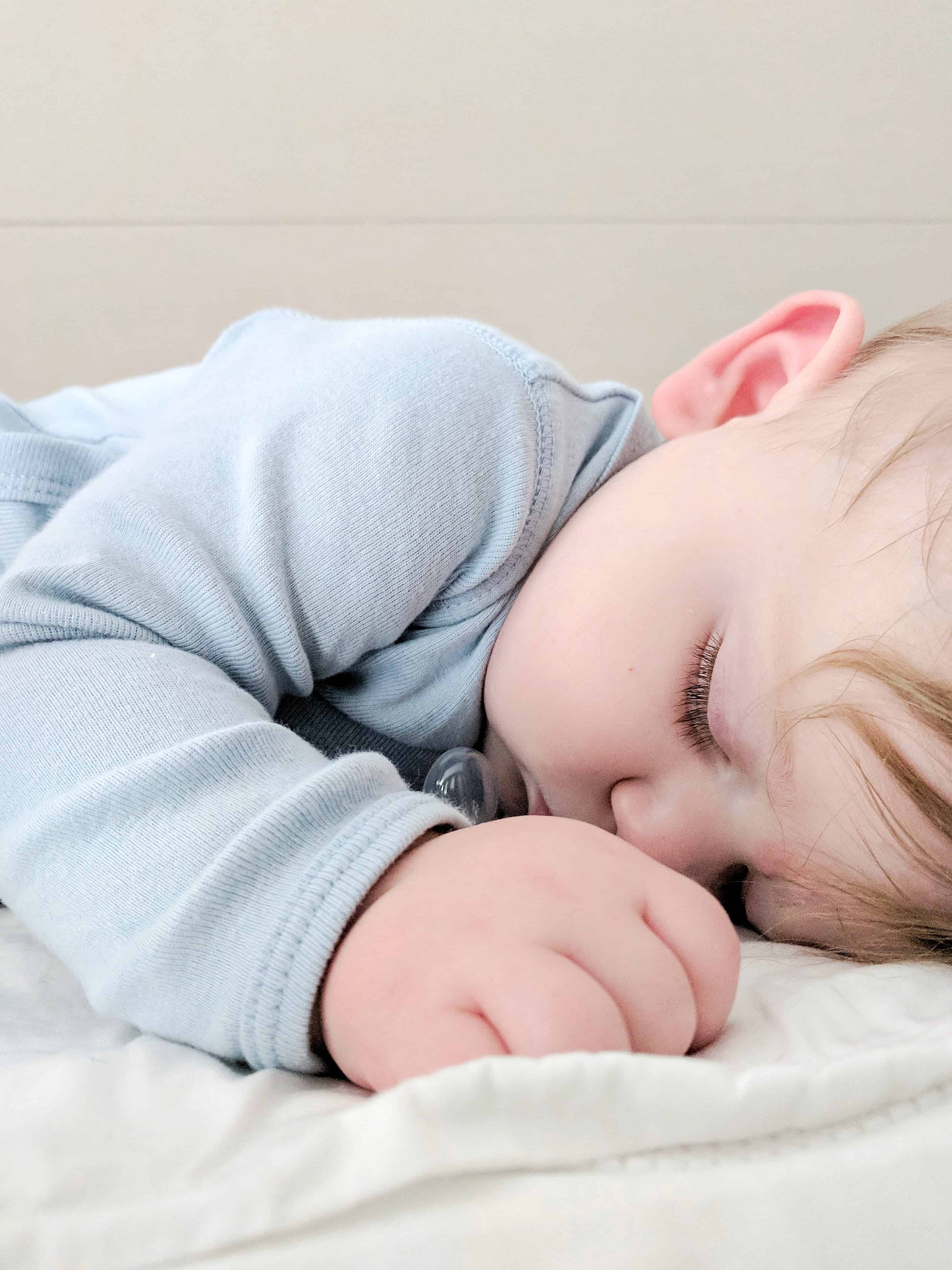 sleeping baby in blue onsie