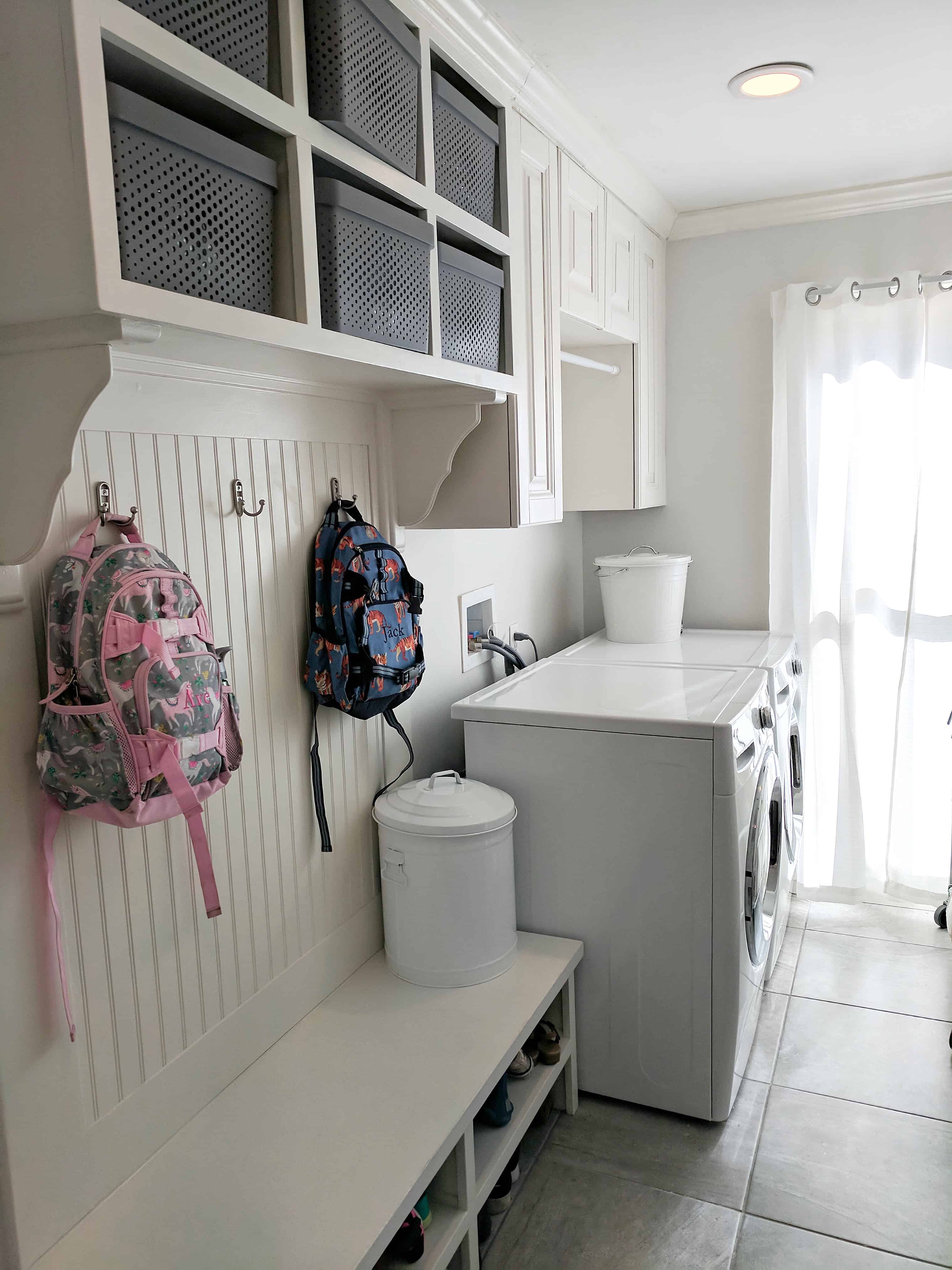 laundry room with pottery barn backpacks and white bins | Simplifying Laundry Day 