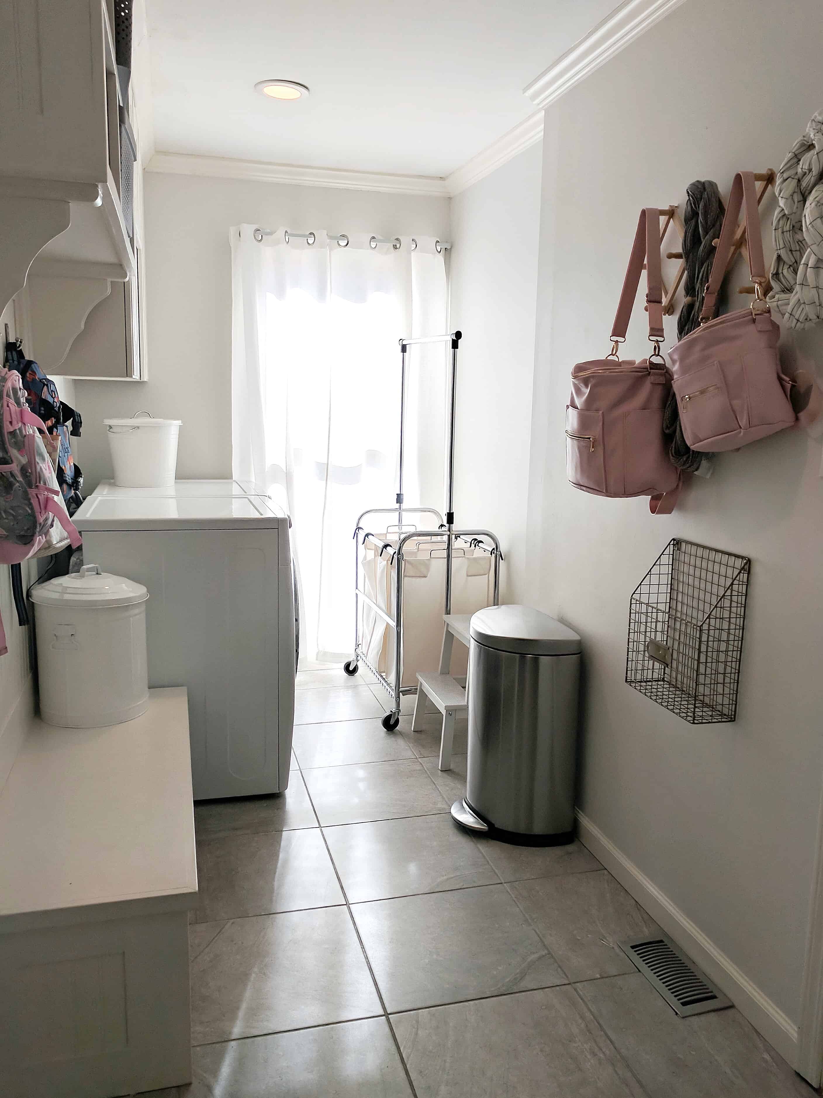 laundry room with pottery barn backpacks and white bins | Simplifying Laundry Day  