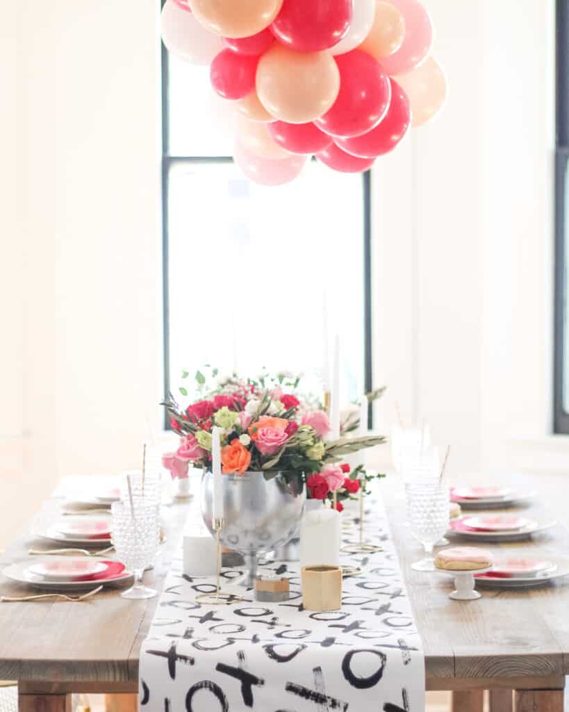 Valentine's day dinner table setting with roses and balloons