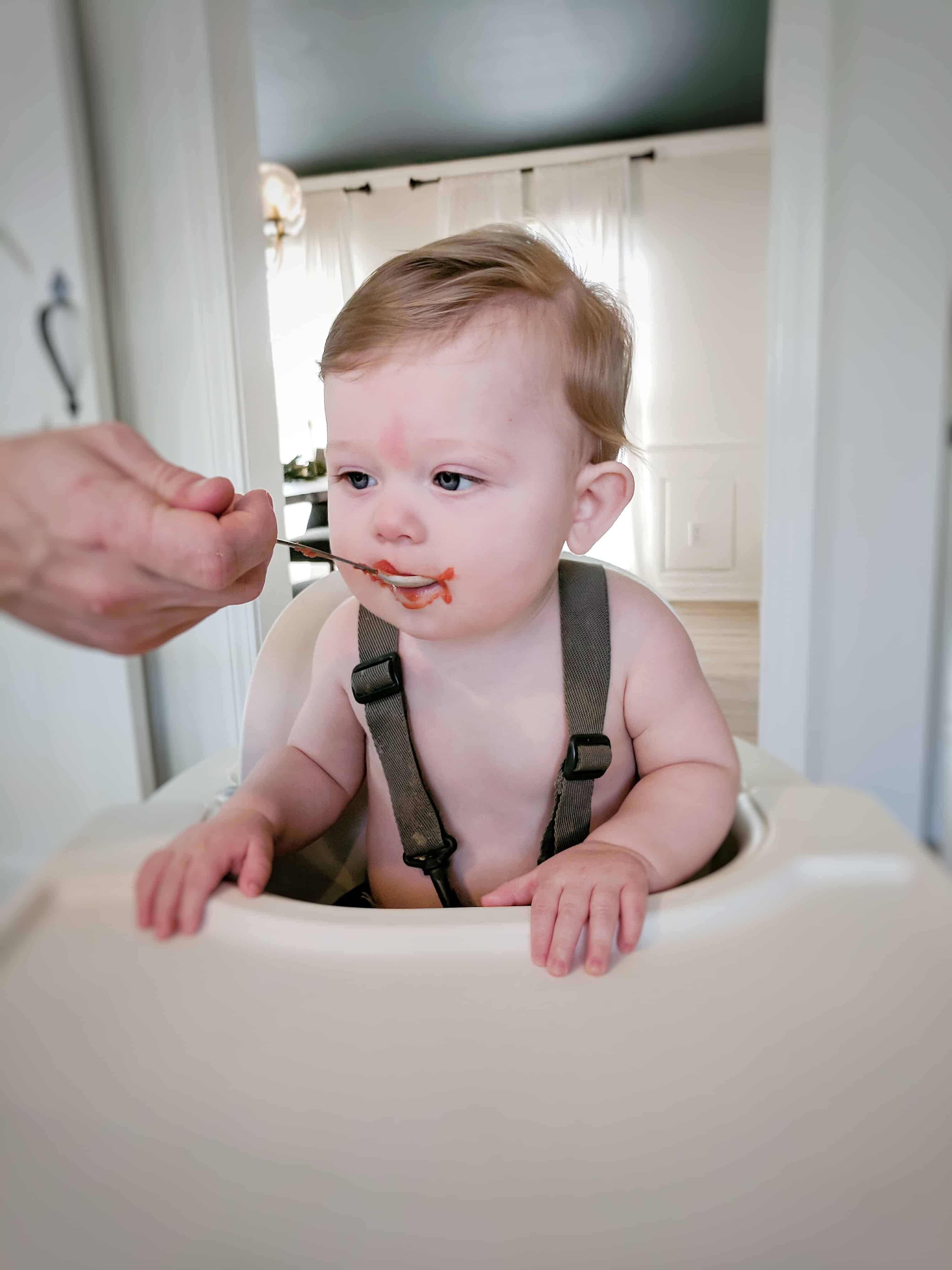 baby being fed in highchair