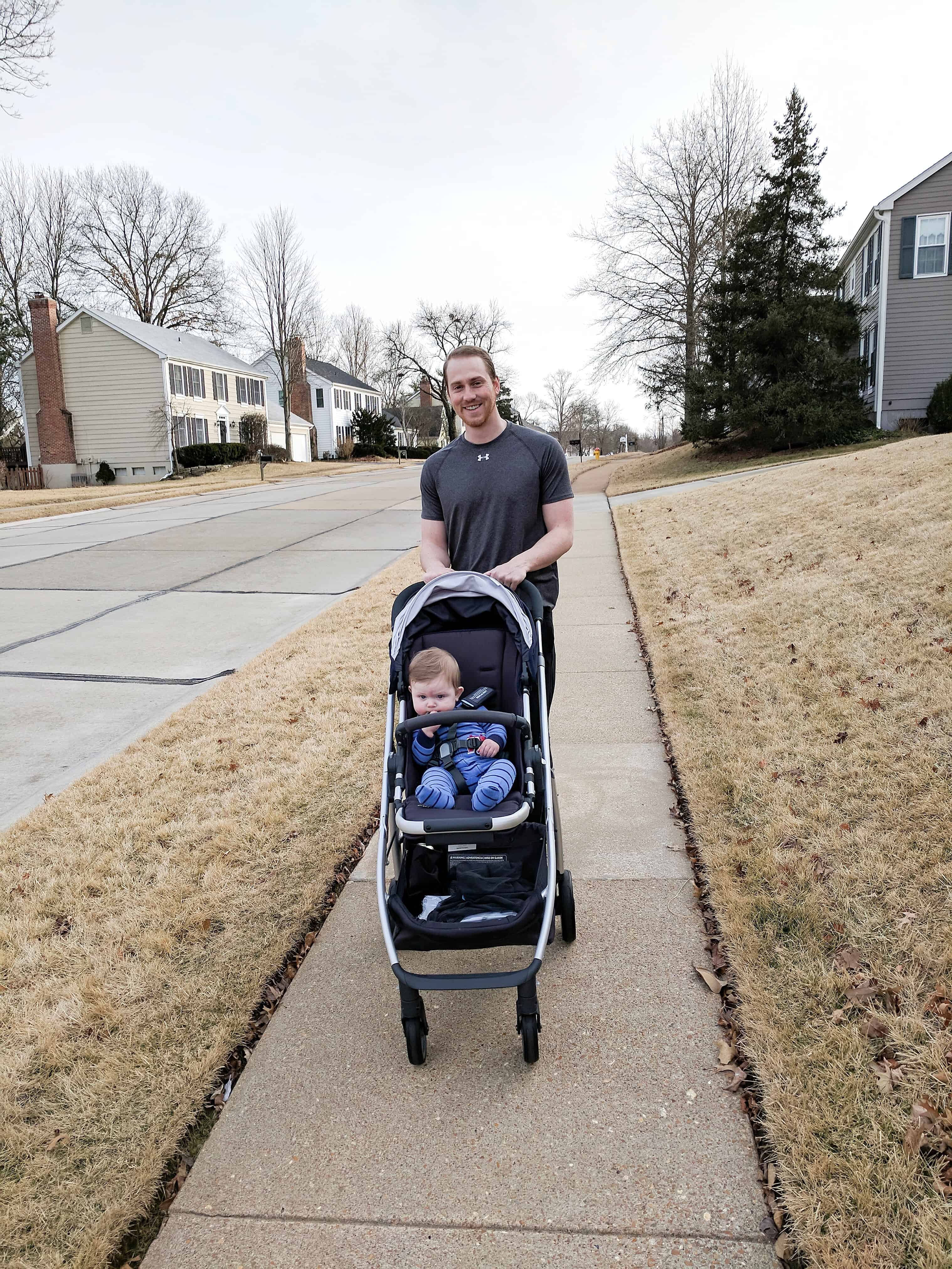 Dad pushing baby in stroller on sidewalk | Buying a stroller 