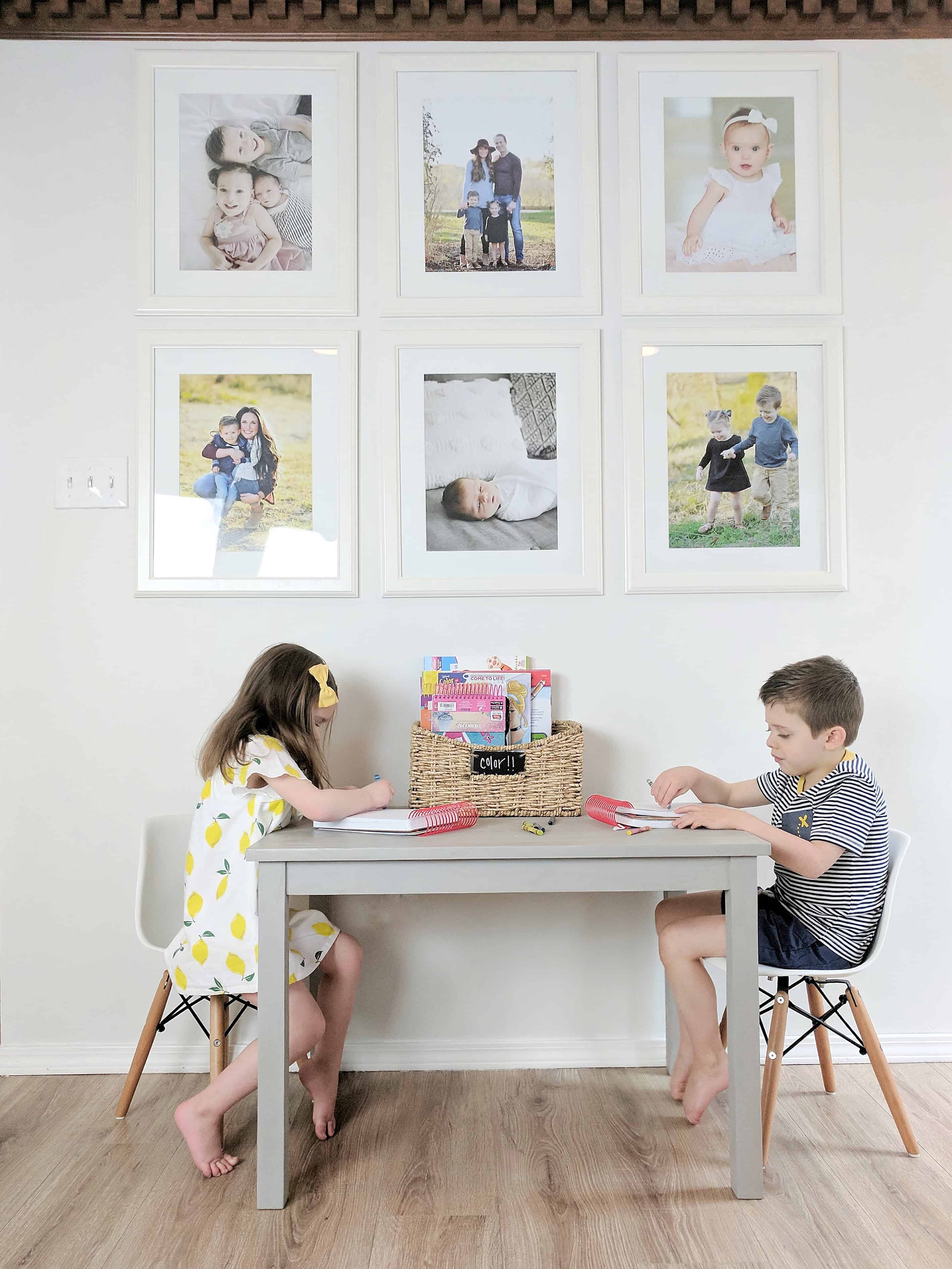 kids coloring at grey table with gallary wall over them