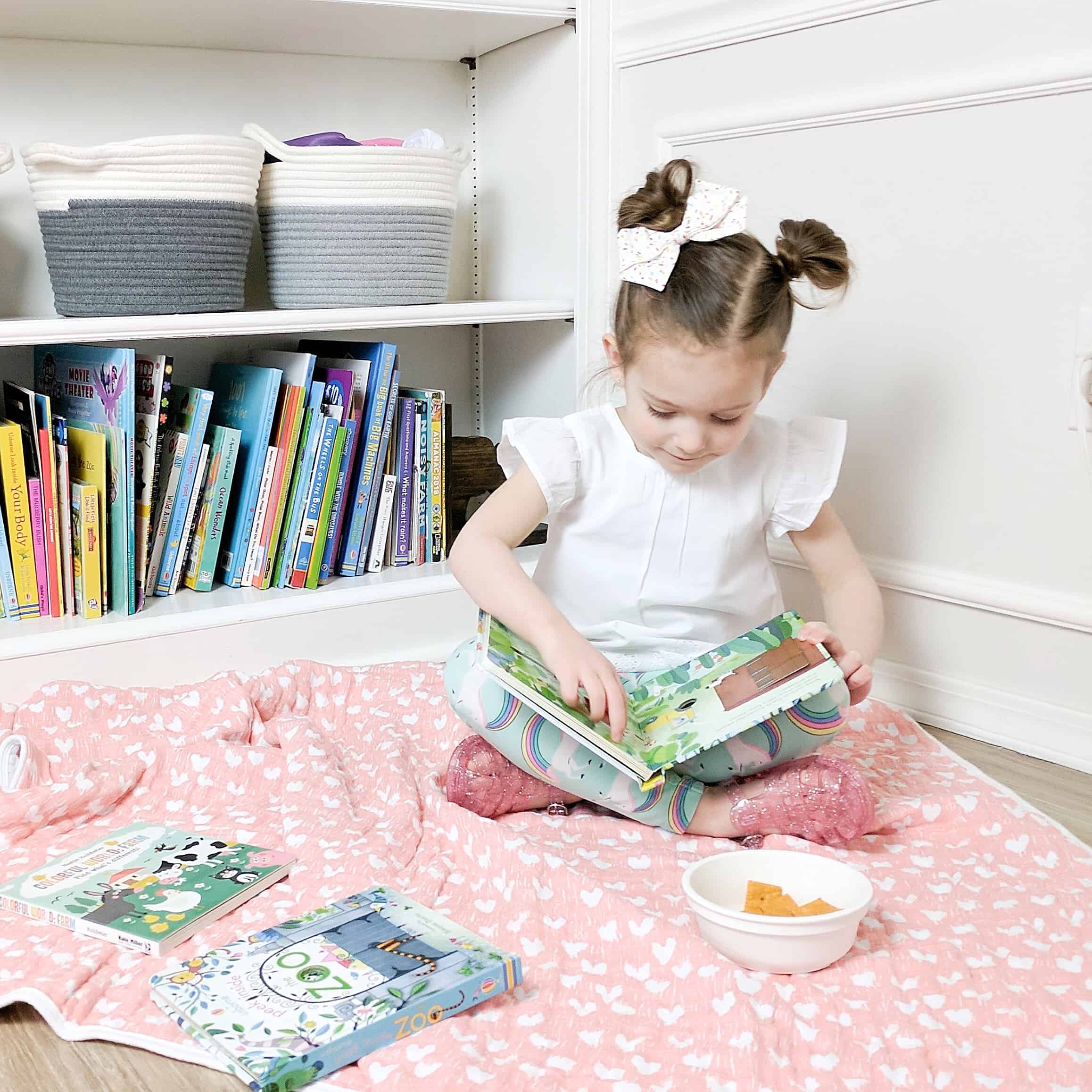 Toddler reading on blanket