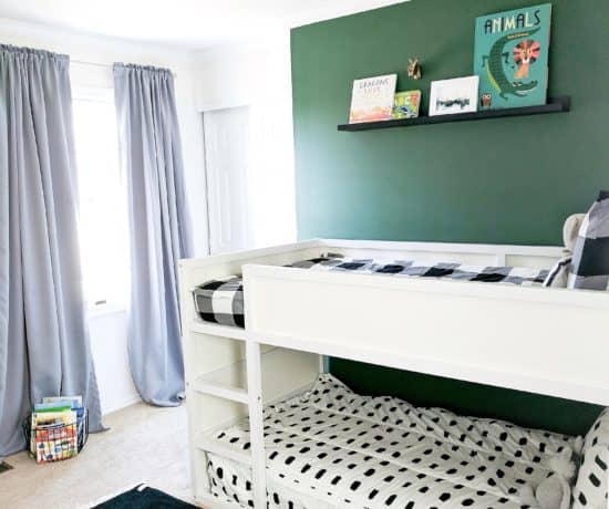 white bunk bed with green wall and black and white bedding