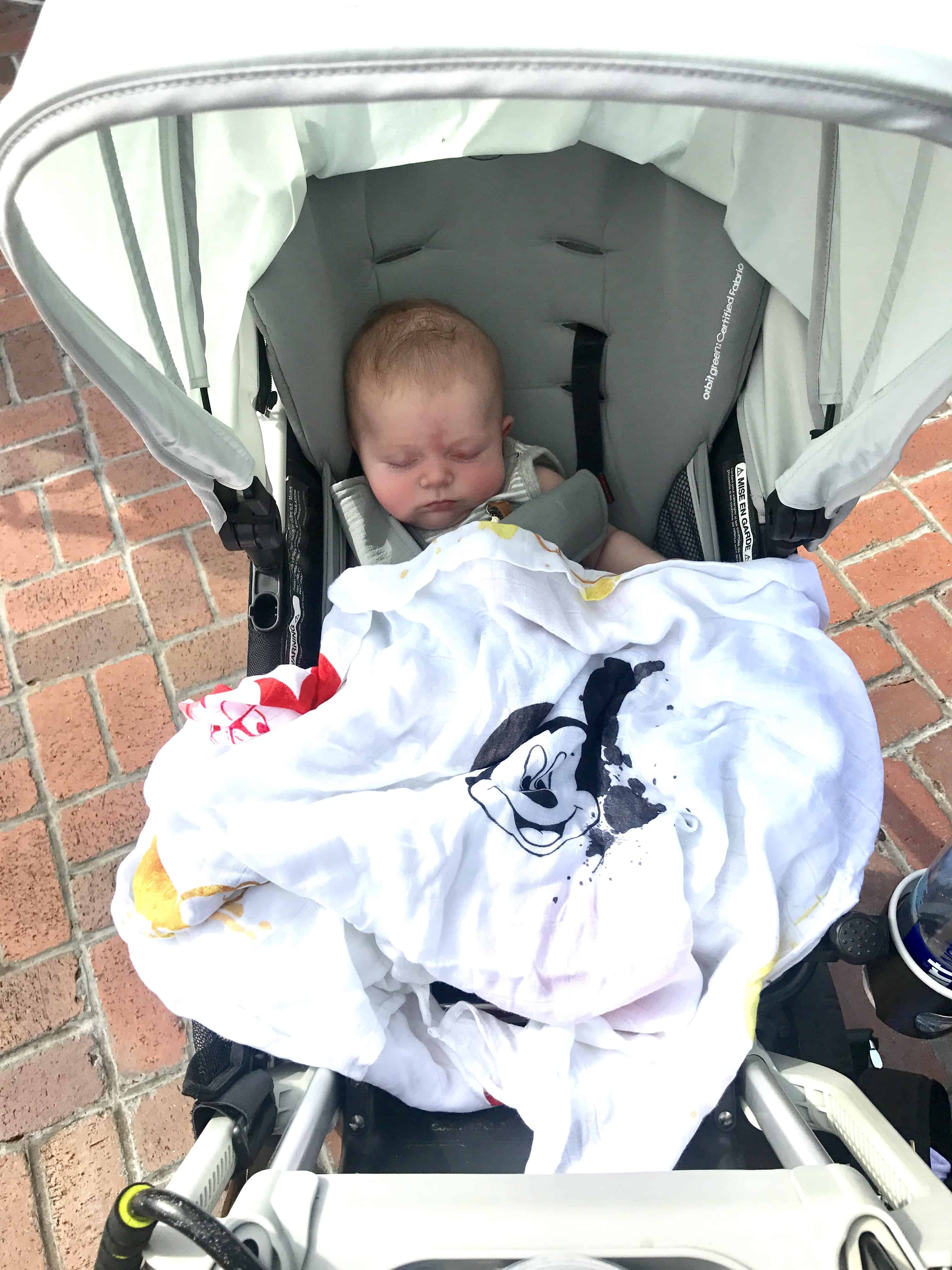 baby in stroller with Mickey Mouse blanket