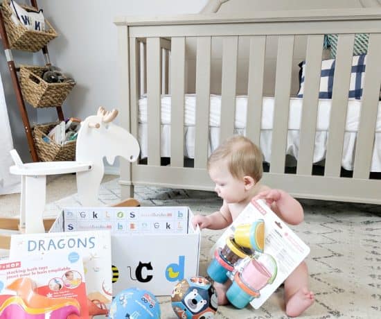 Baby on floor by rocking horse and crib with gifts