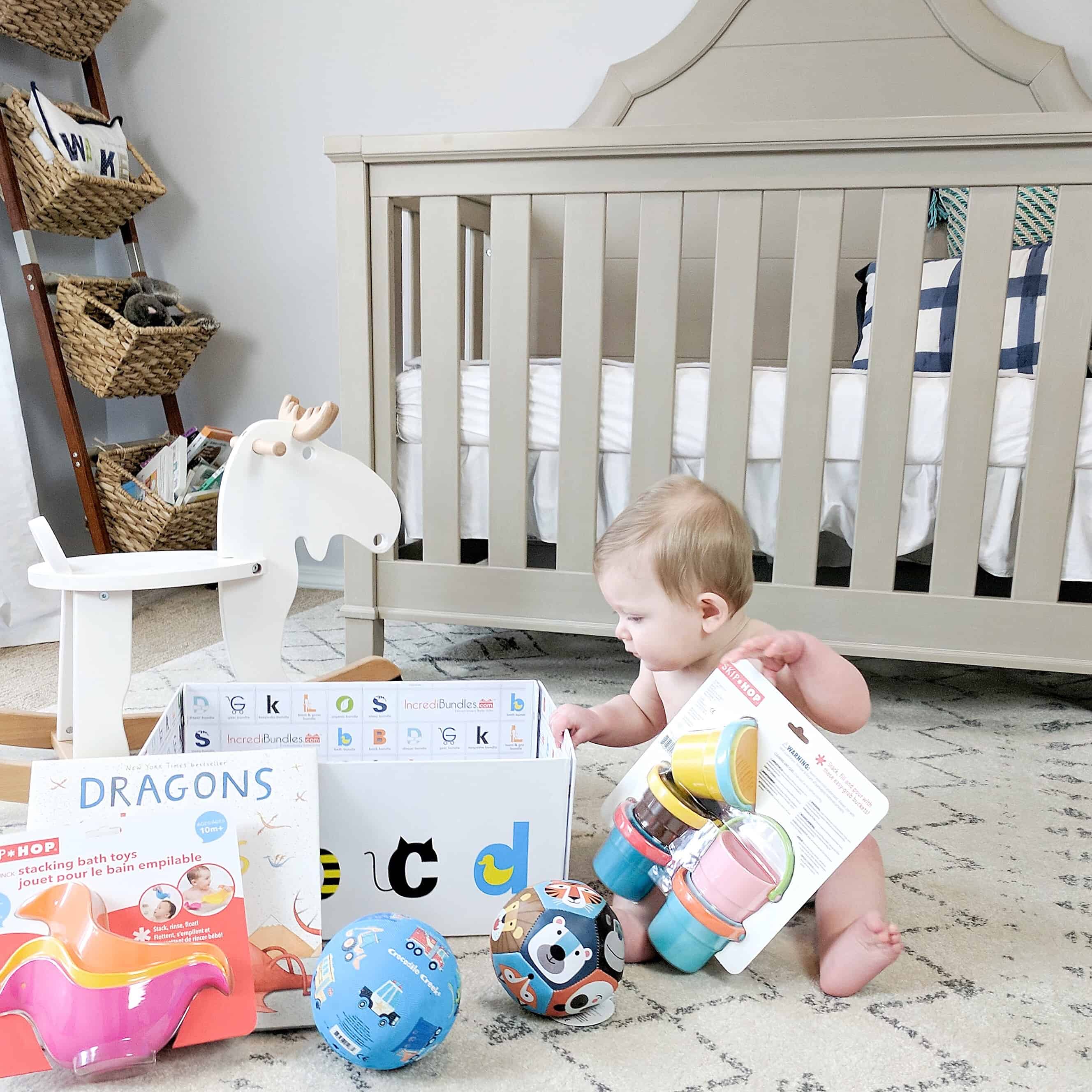 Baby on floor by rocking horse and crib with gifts