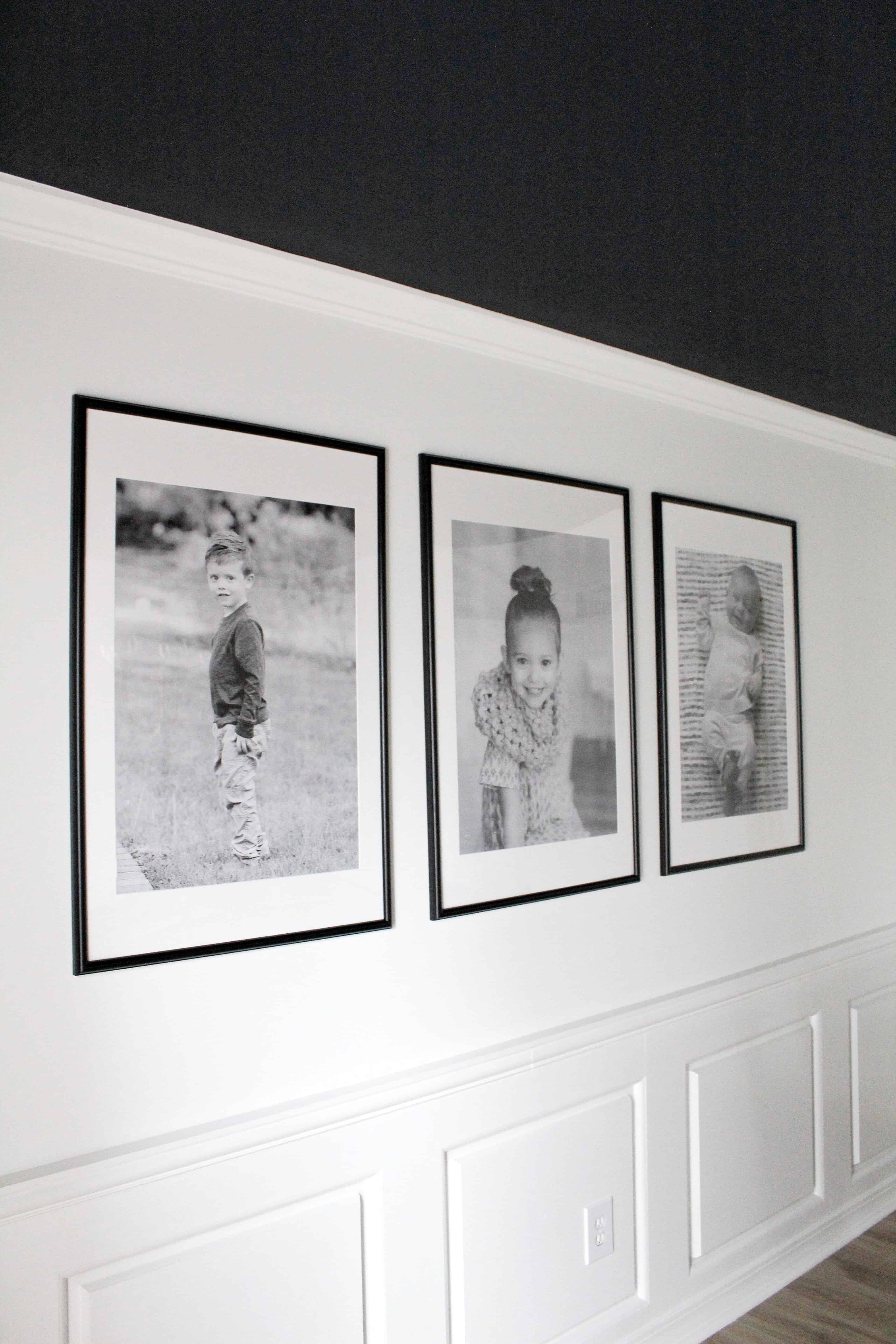 White wall with three large black frames and engineering prints | Modern Dining Room with Dark Ceiling