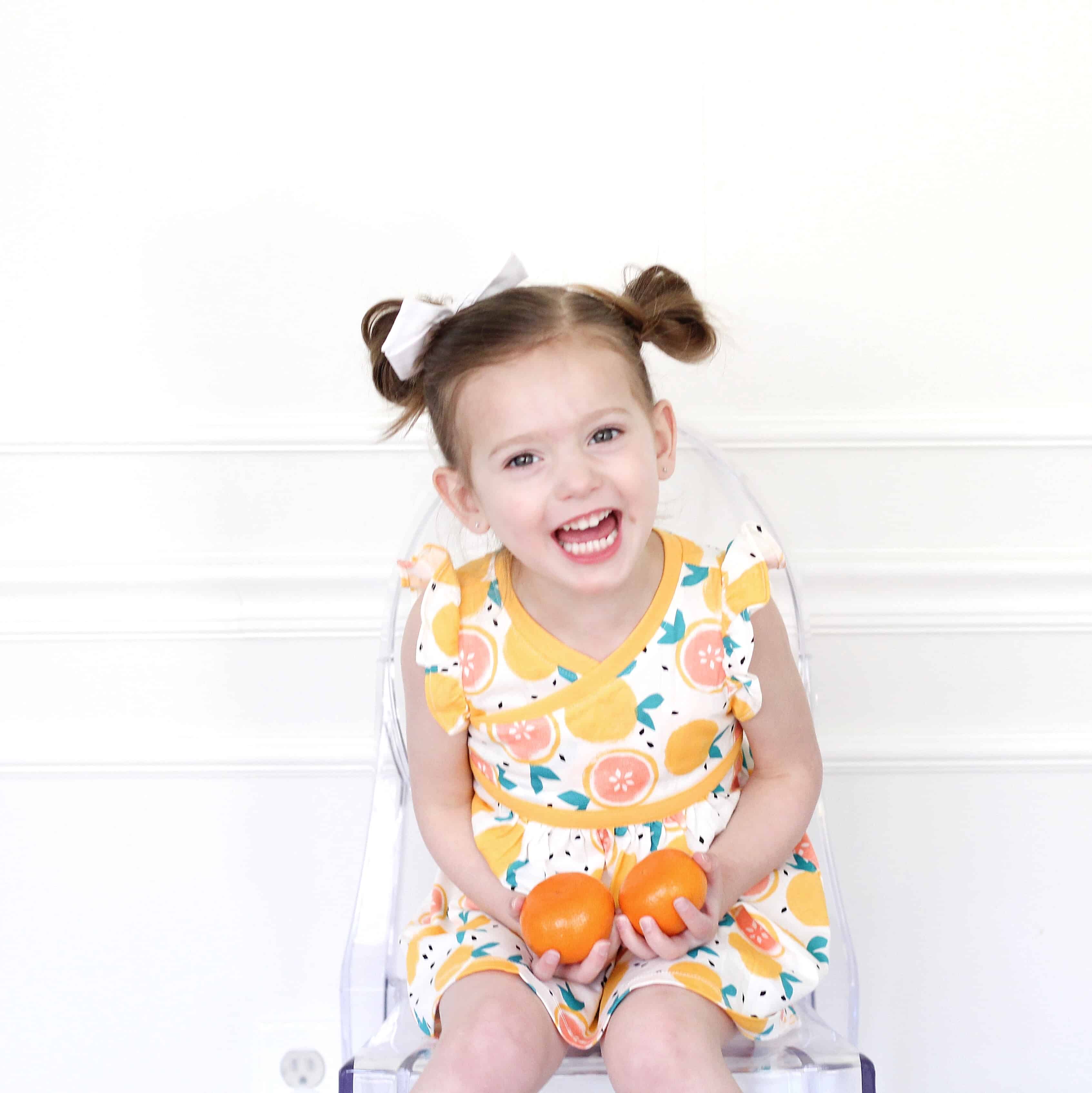 toddler girl in clementine dress from tea collection
