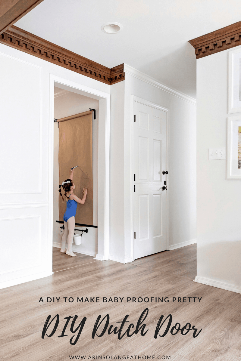 Little girl coloring on a wall mounted easel 