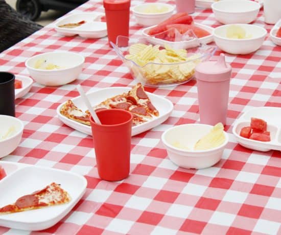 red and white table cloth with plates and cups