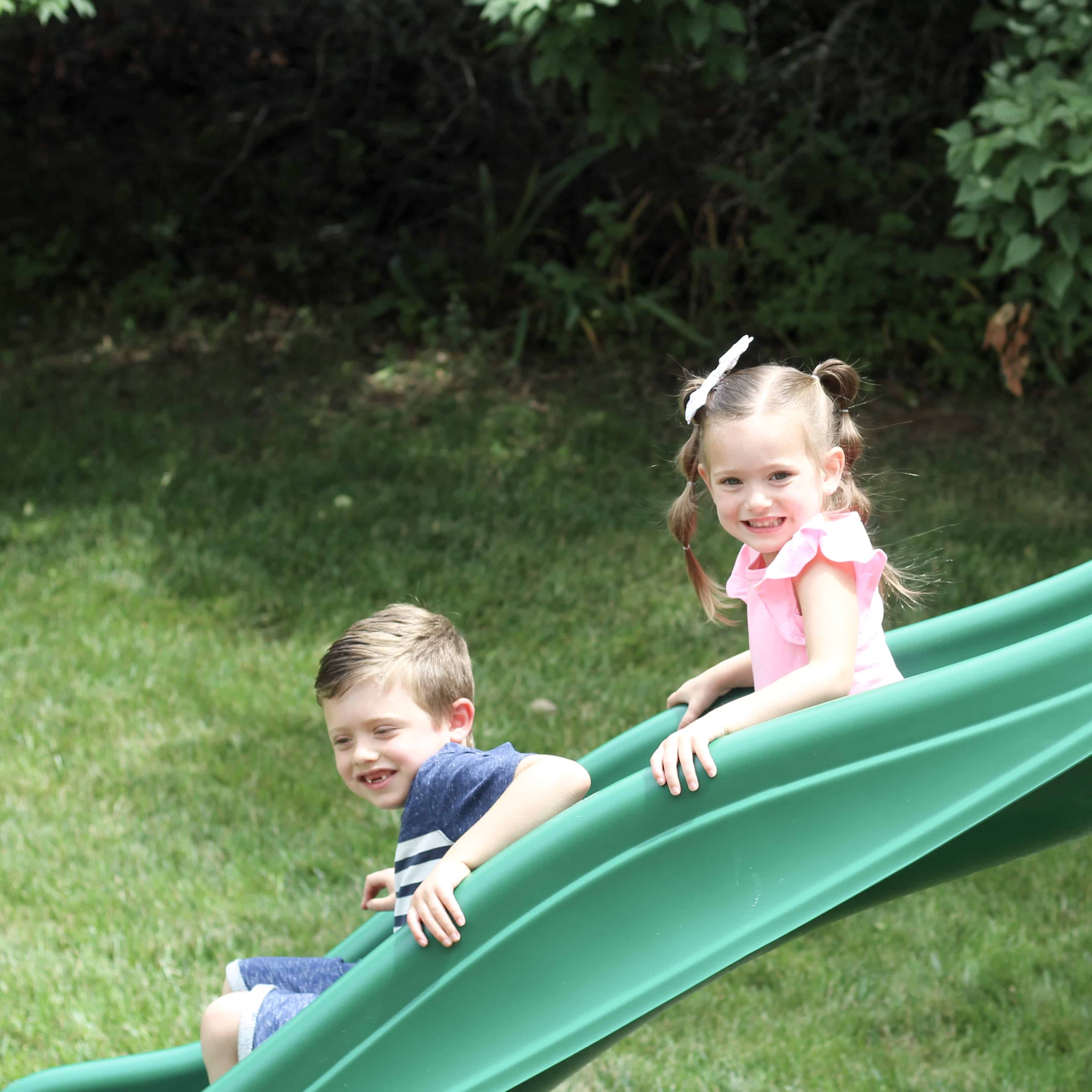 siblings going down slide