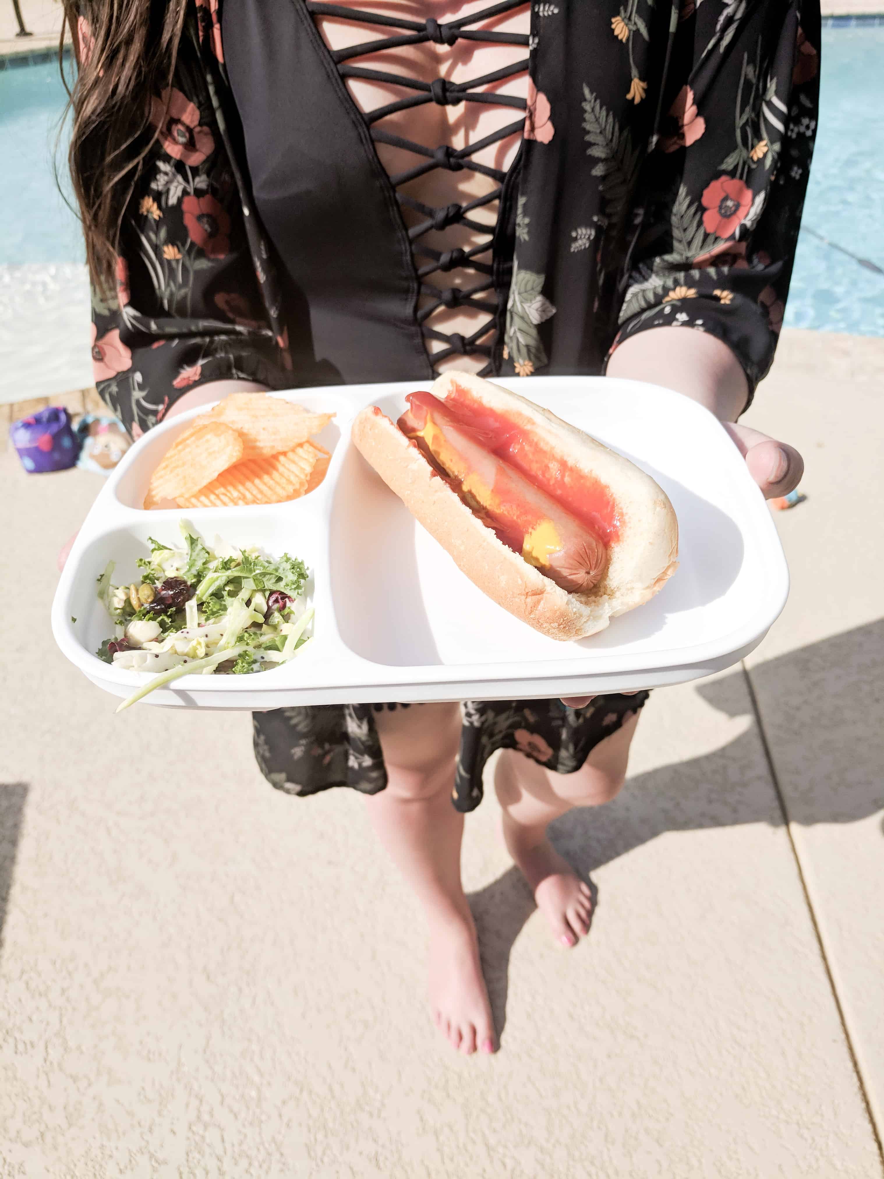 holding hotdog on replay recycled plate