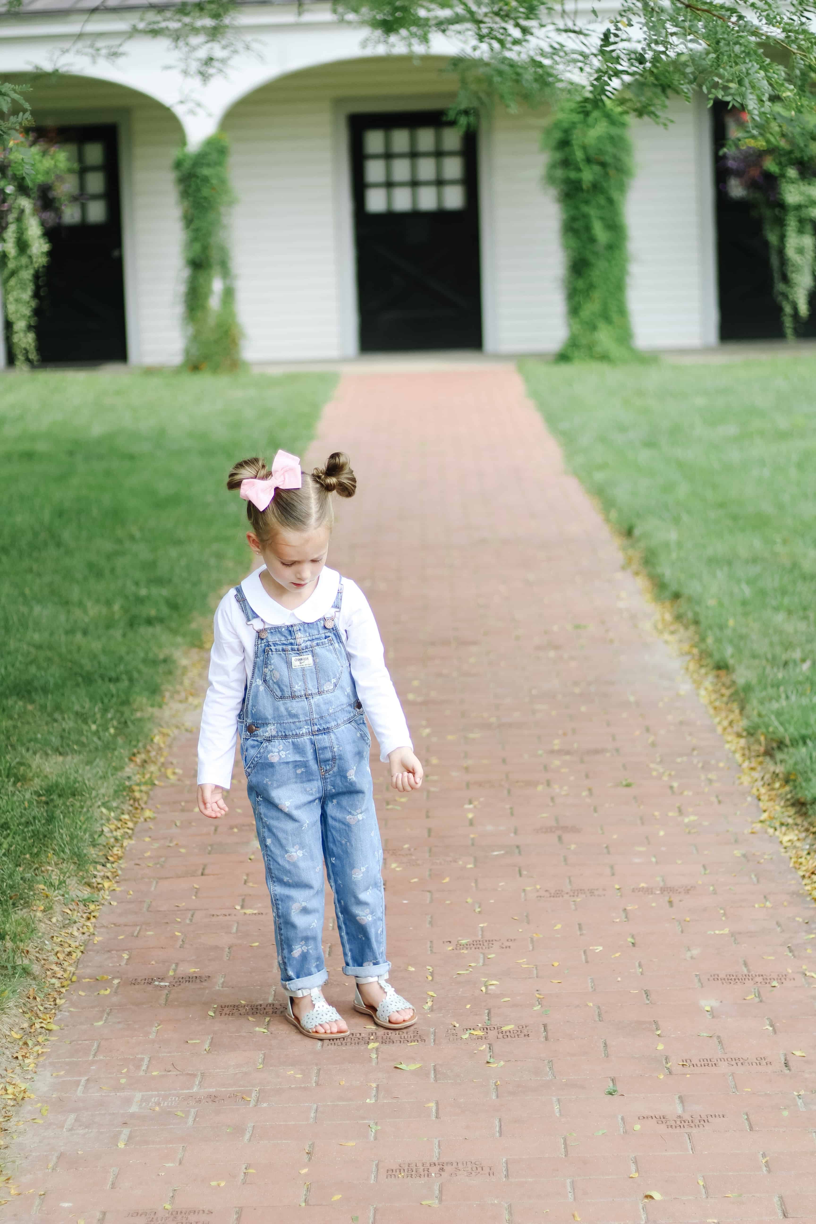 toddler girl in OshKosh overalls