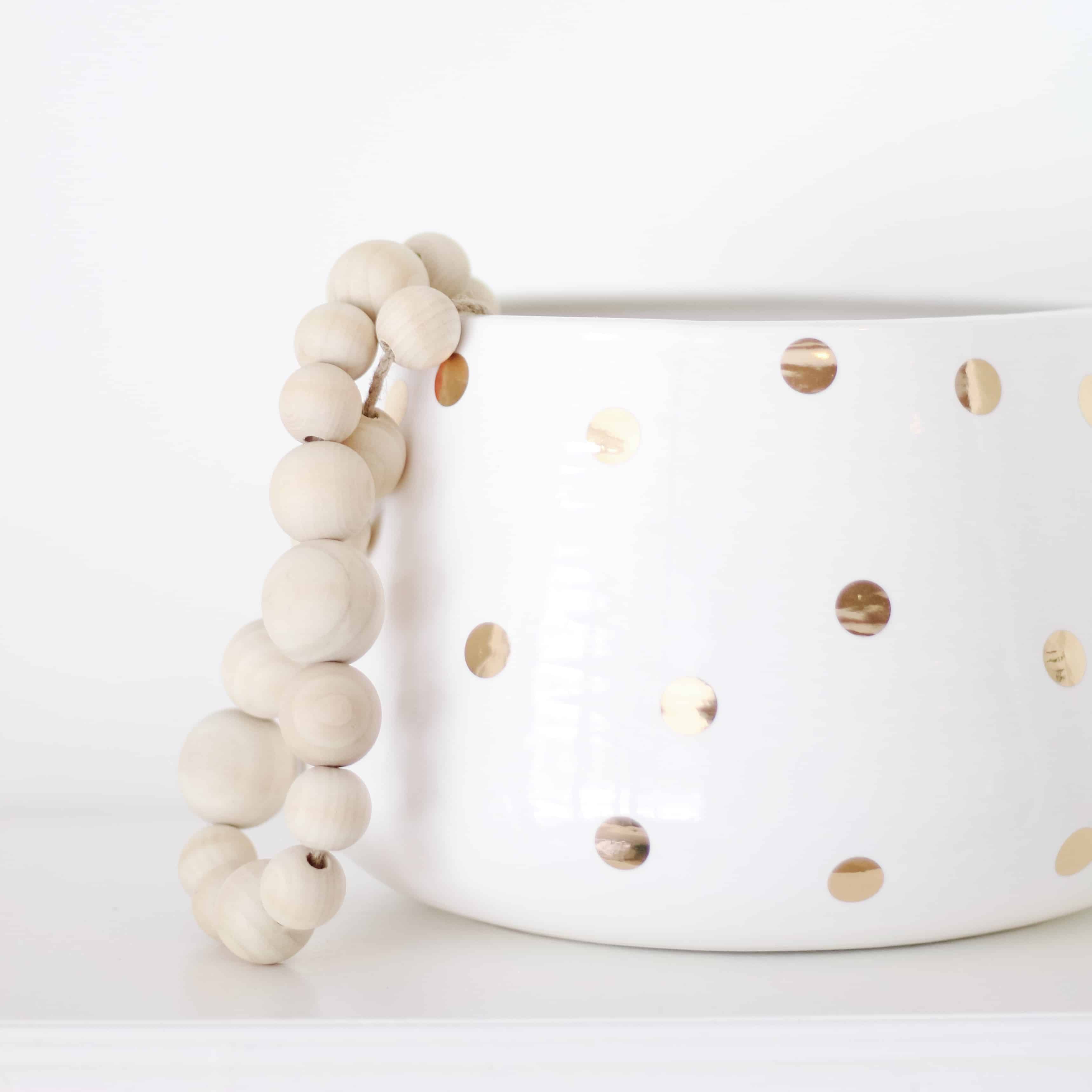 White and gold vase with wood bead strand