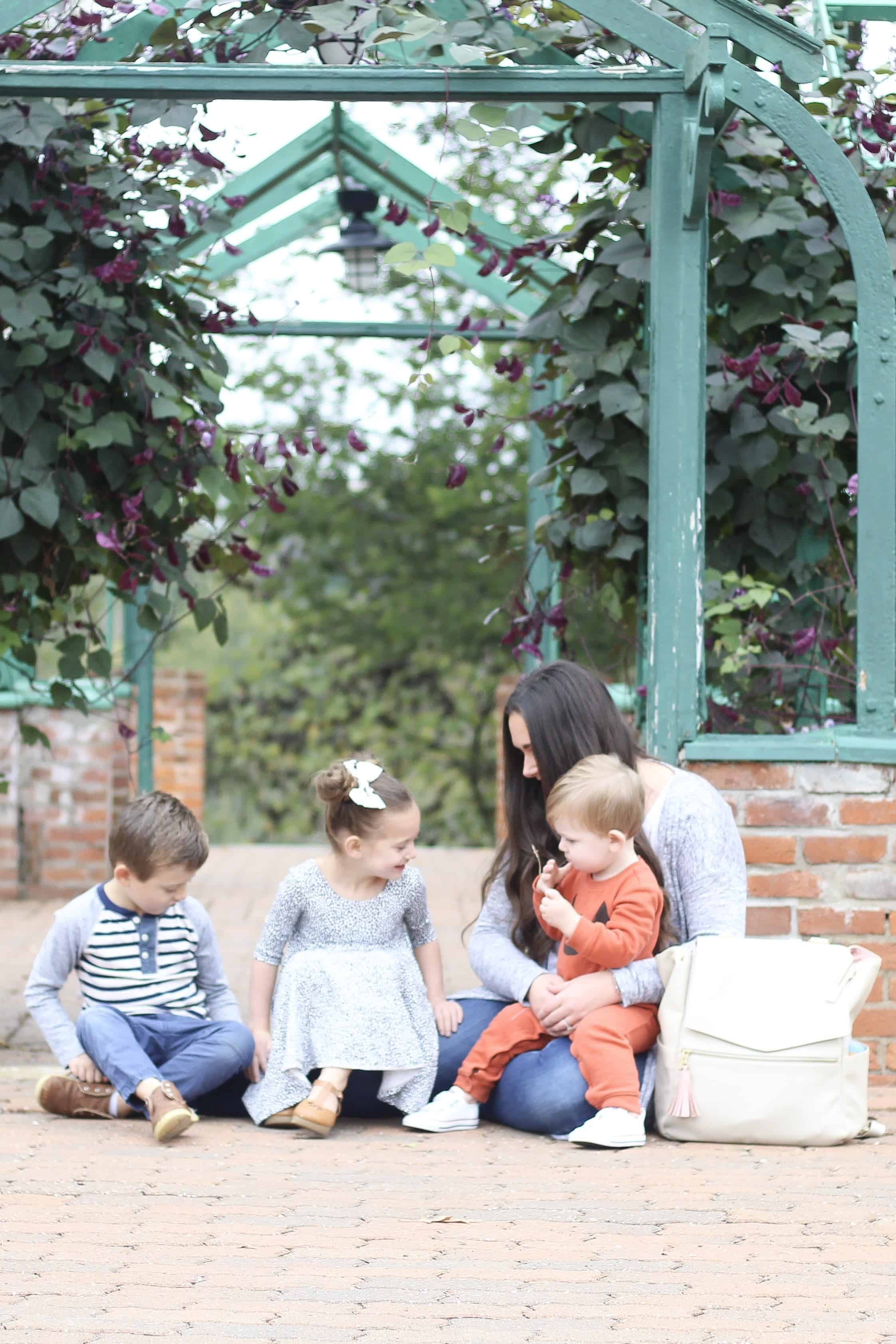 Freshly Picked Diaper bag and mom with 3 little ones sitting on ground