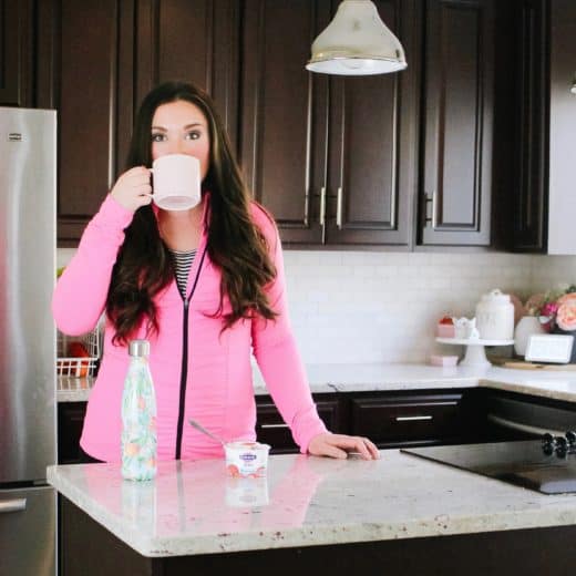 mom drinking coffee in kitchen with pink sweatshirt on