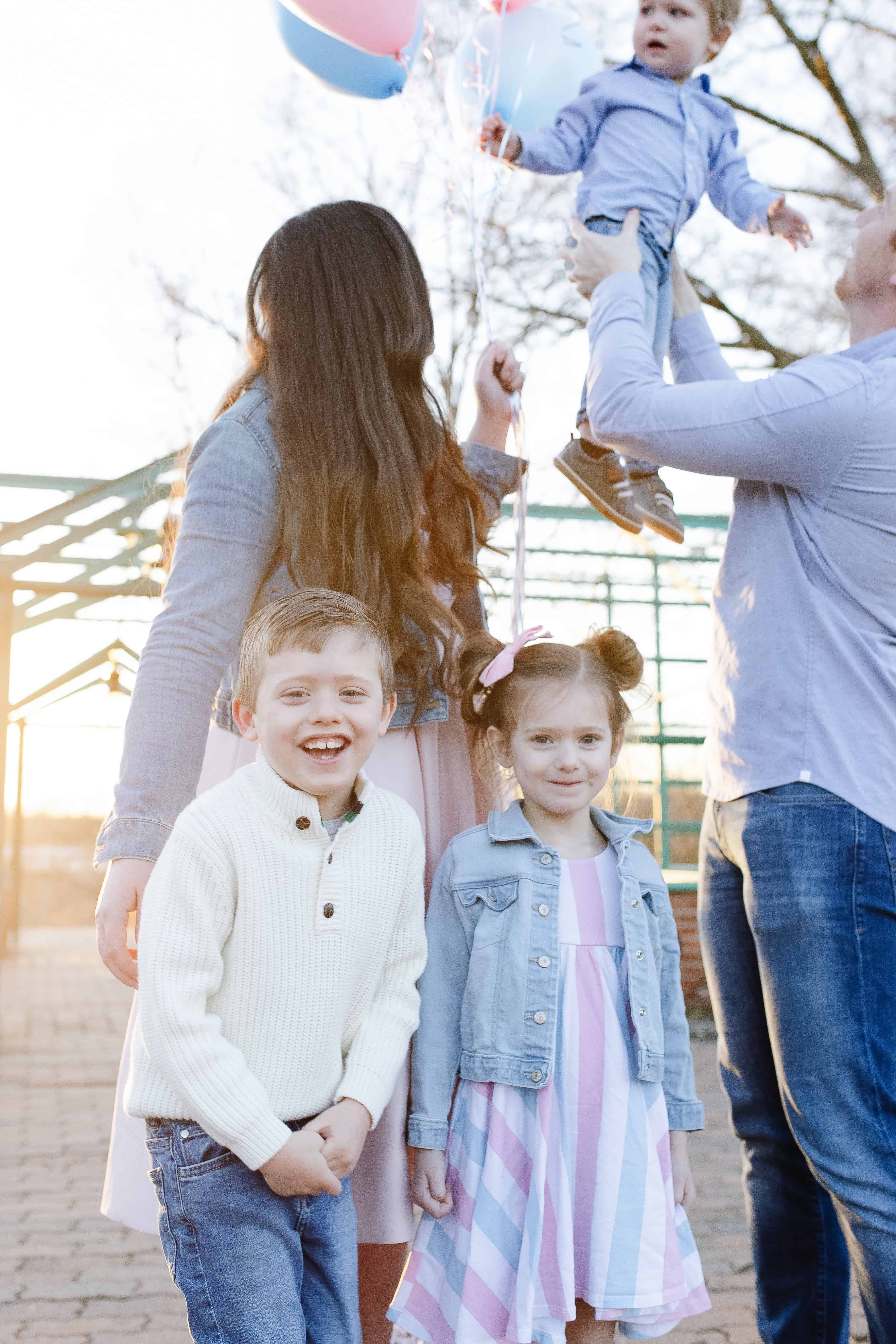 family of 5 with pink and blue balloons