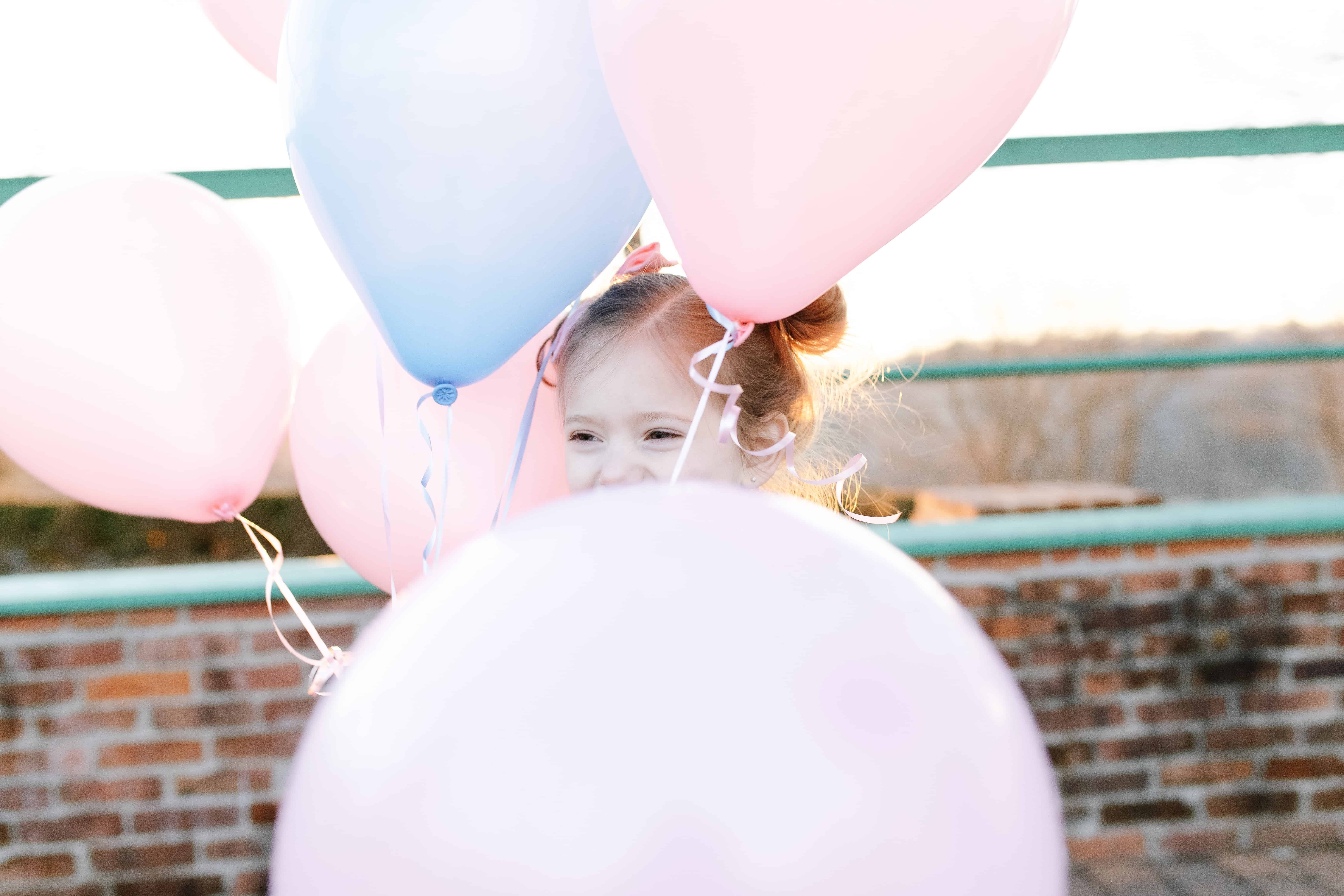 Little girl in pink and blue balloons