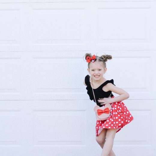 Little Girl dressed for Disney in red and white skirt and black leotard
