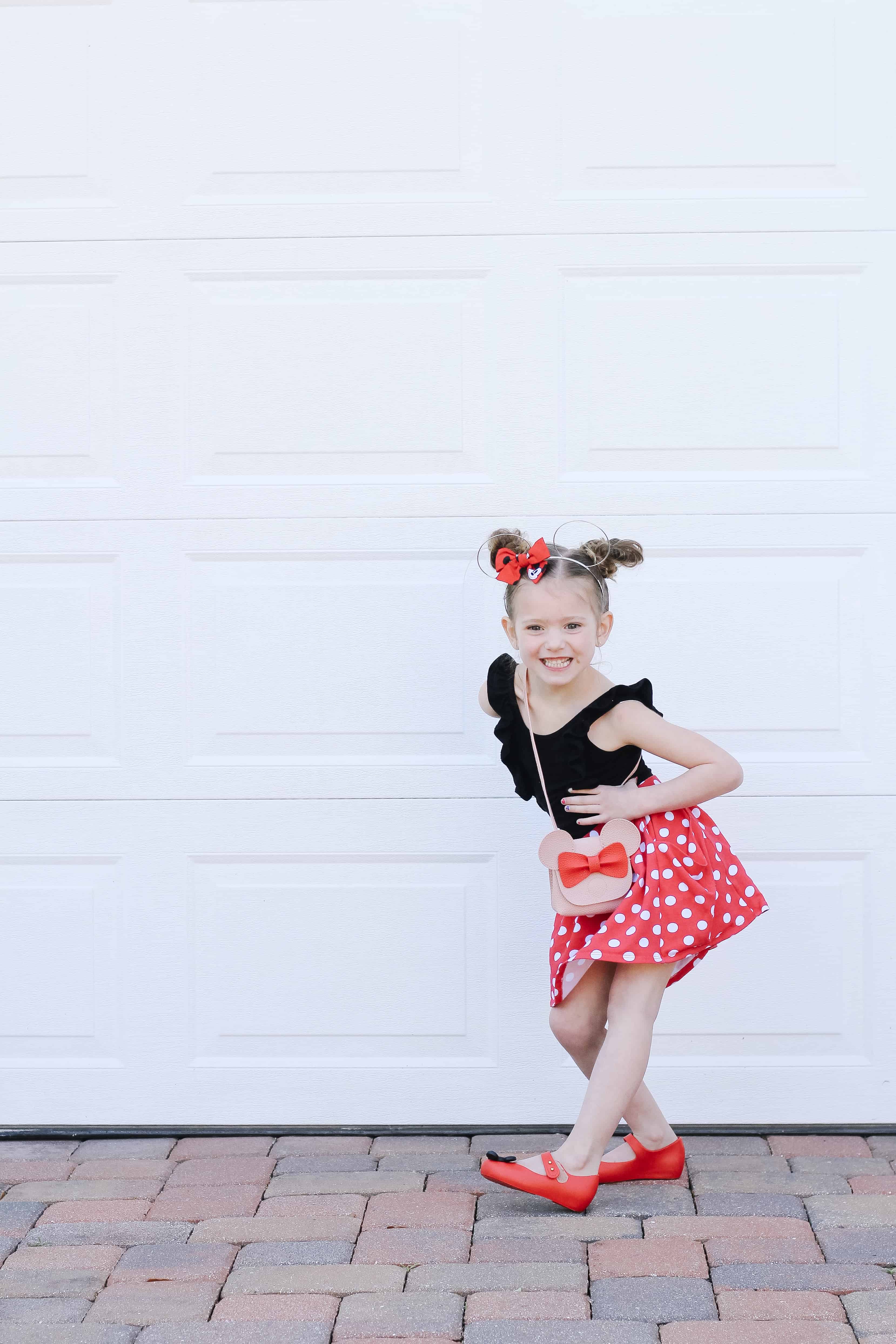 Little Girl dressed for Disney in red and white skirt and black leotard
