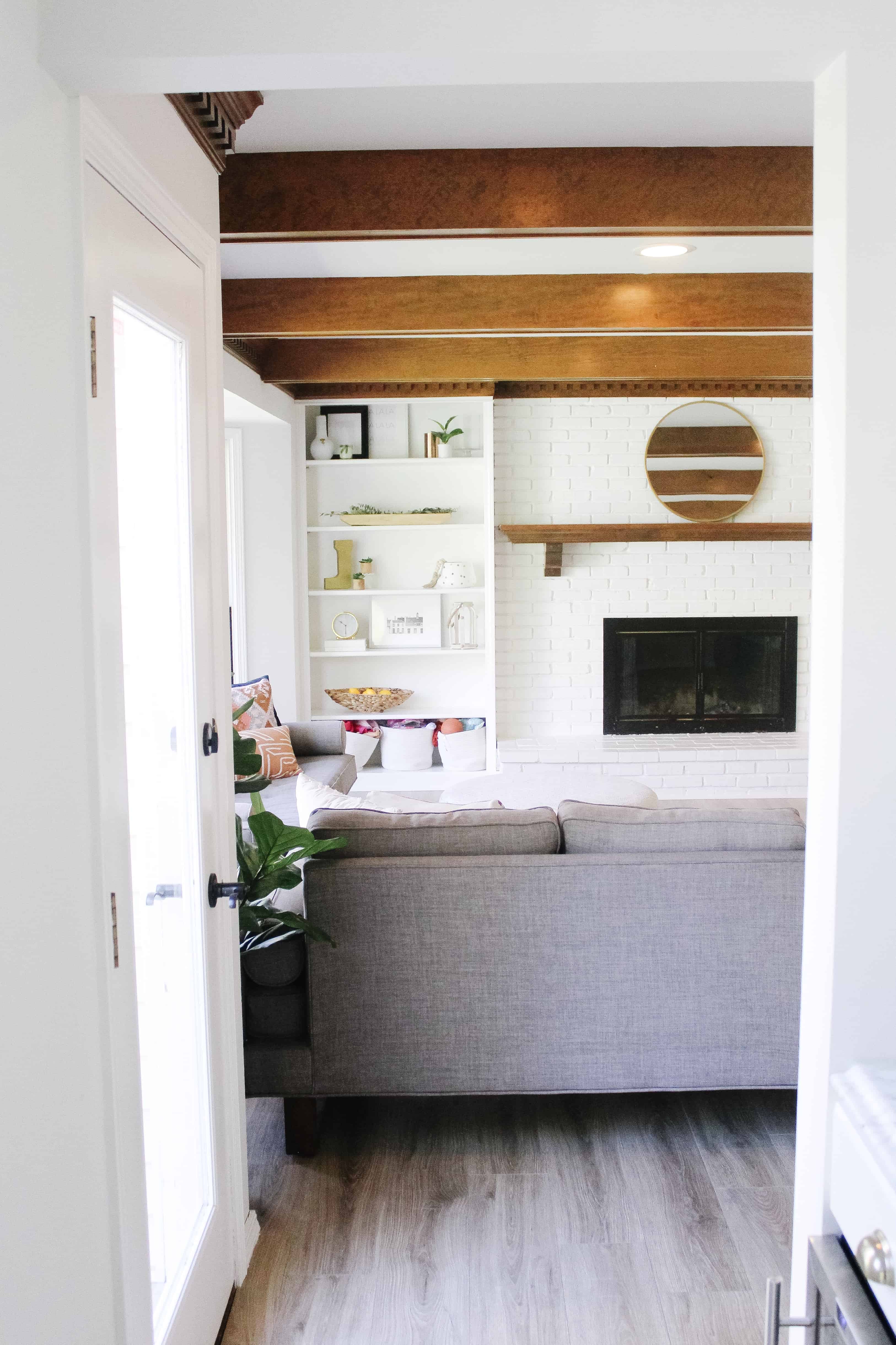 View of living room with back of couch and wood beams