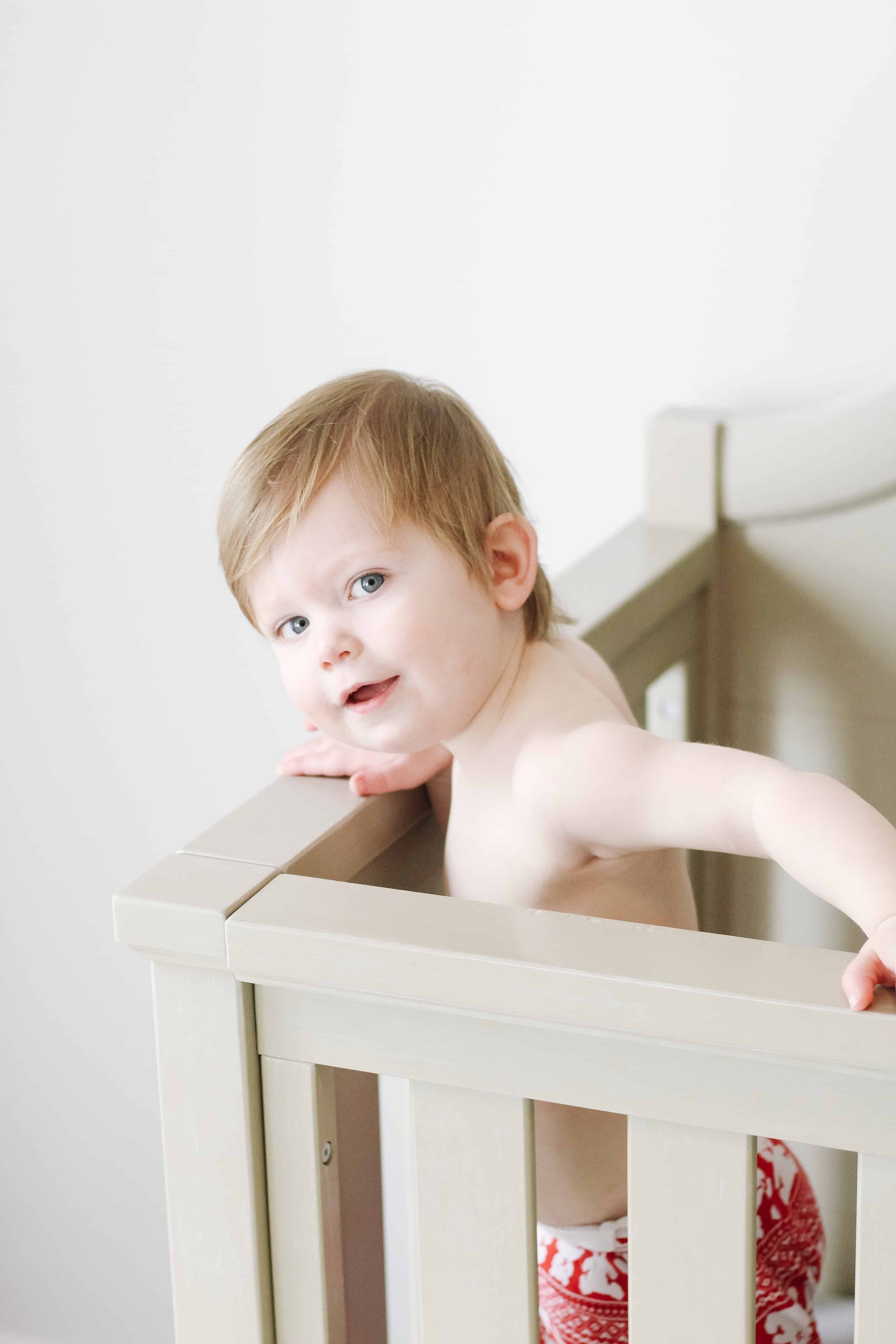 Toddler boy standing in his crib