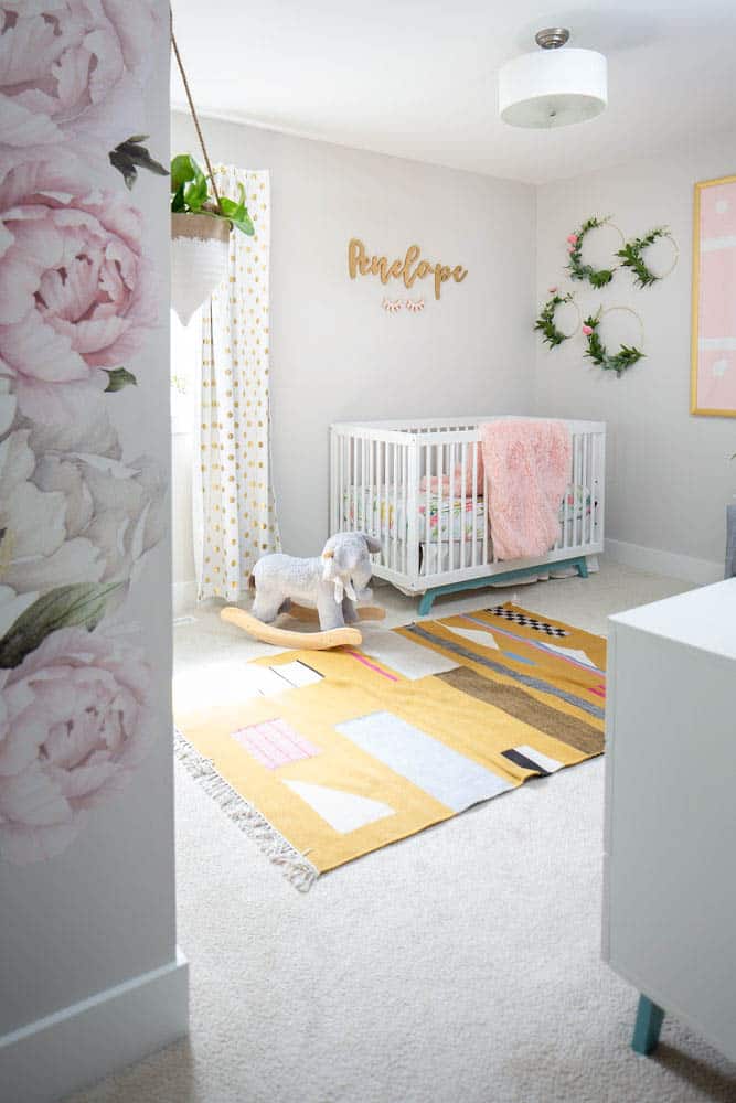 baby girl nursery with yellow rug 