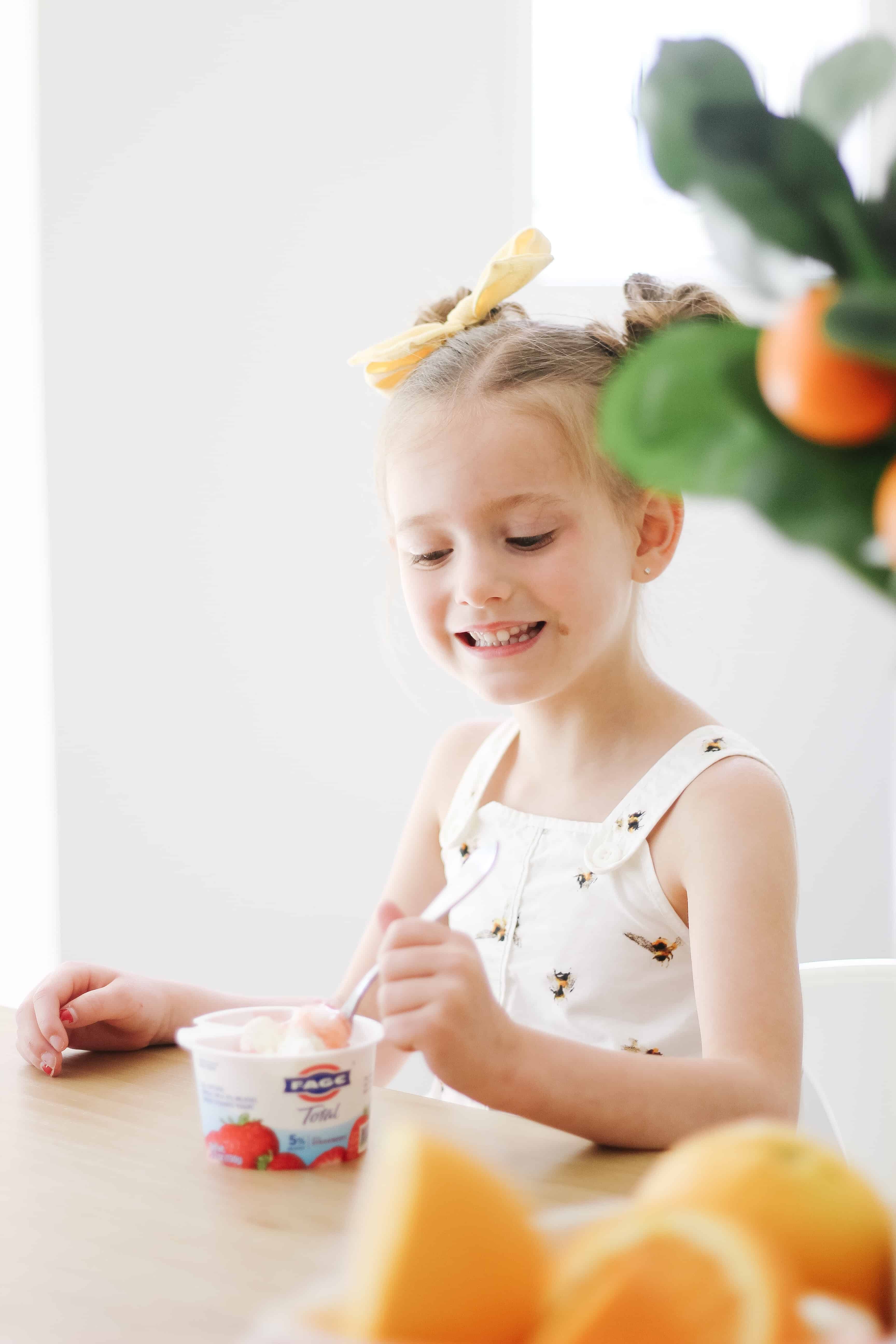 toddler girl eating yogurt