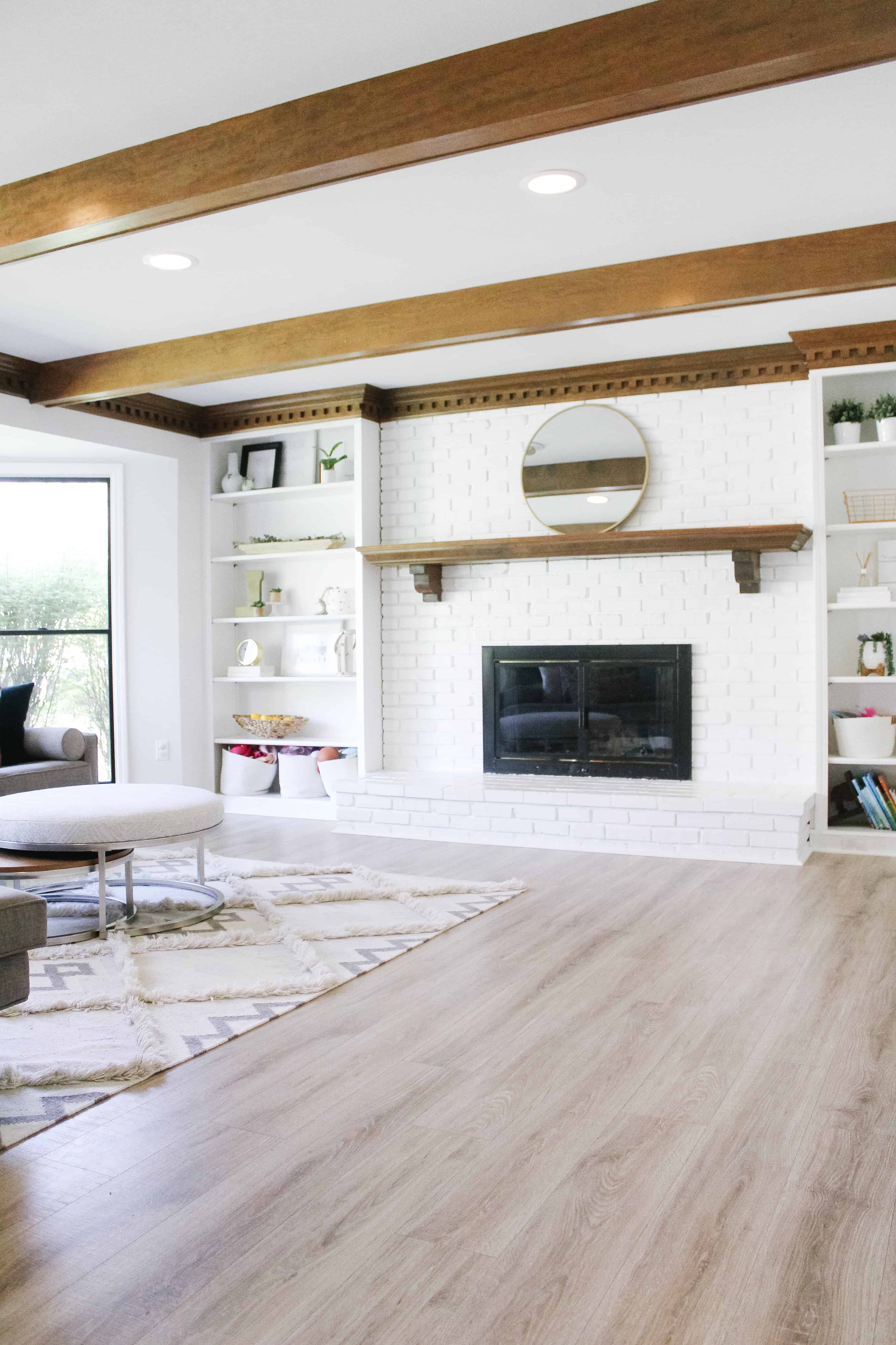 living room with large white fireplace and builtins