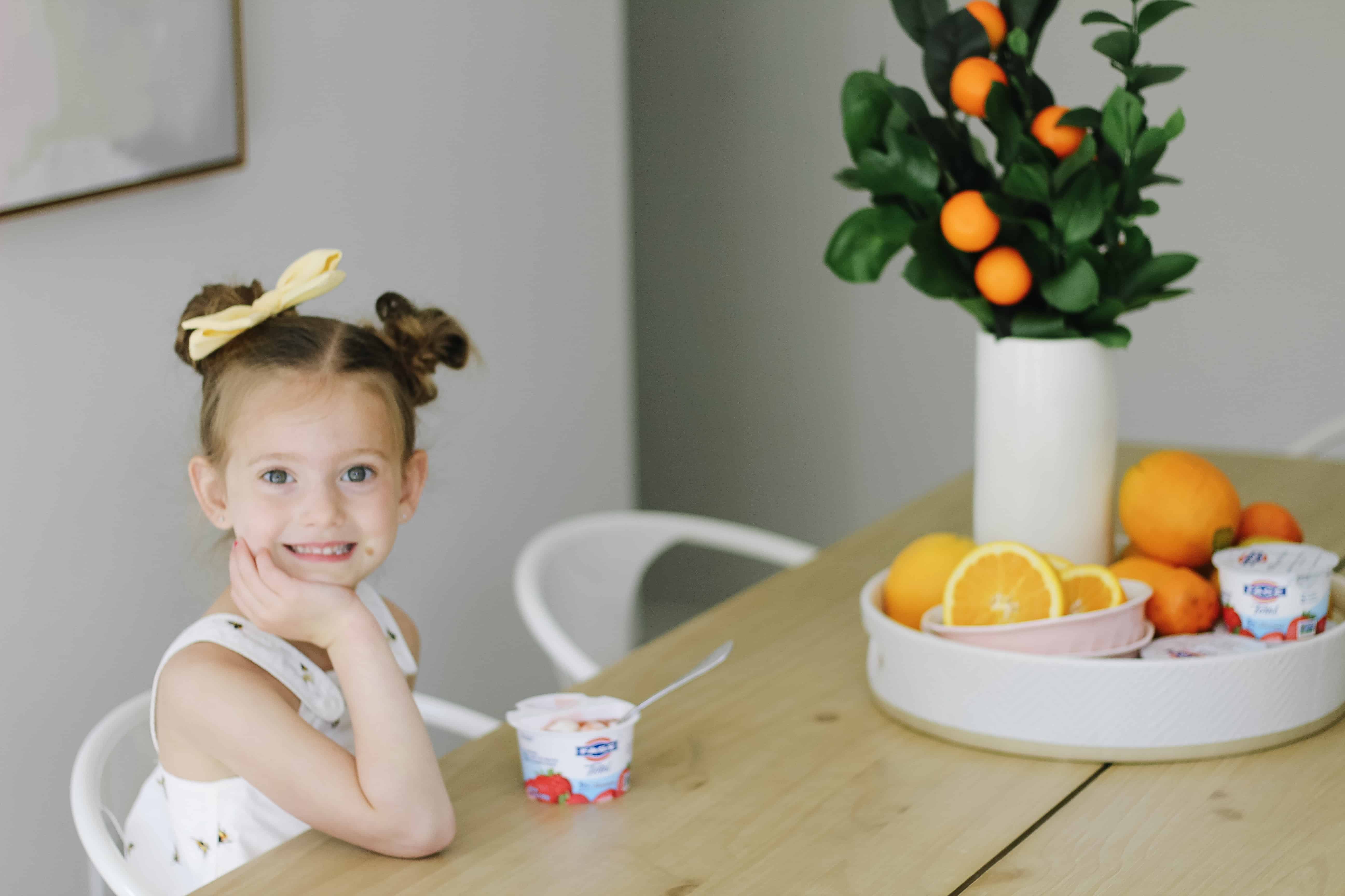 toddler girl at kitchen table eating 