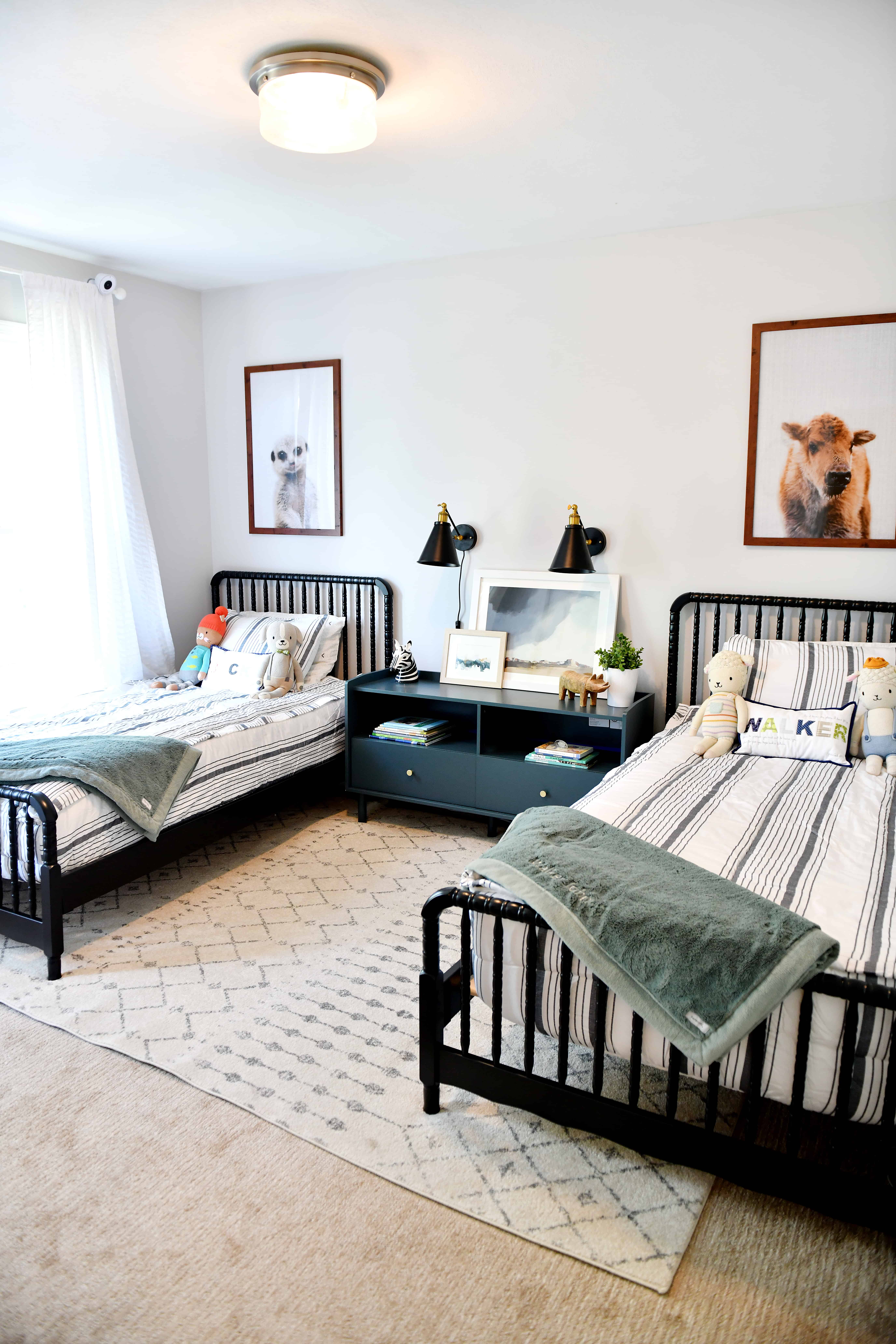 bedroom with two black beds and animal photos over bed