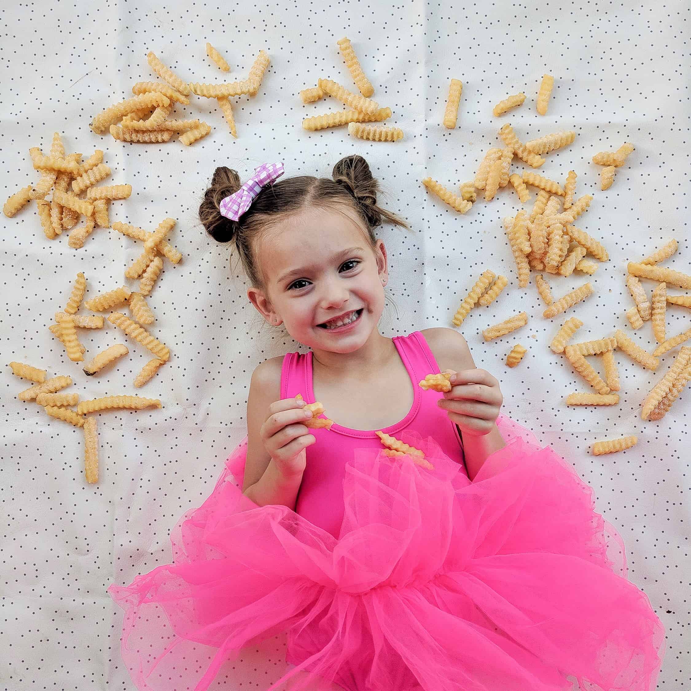 little girl in pink tutu surrounded by French fry