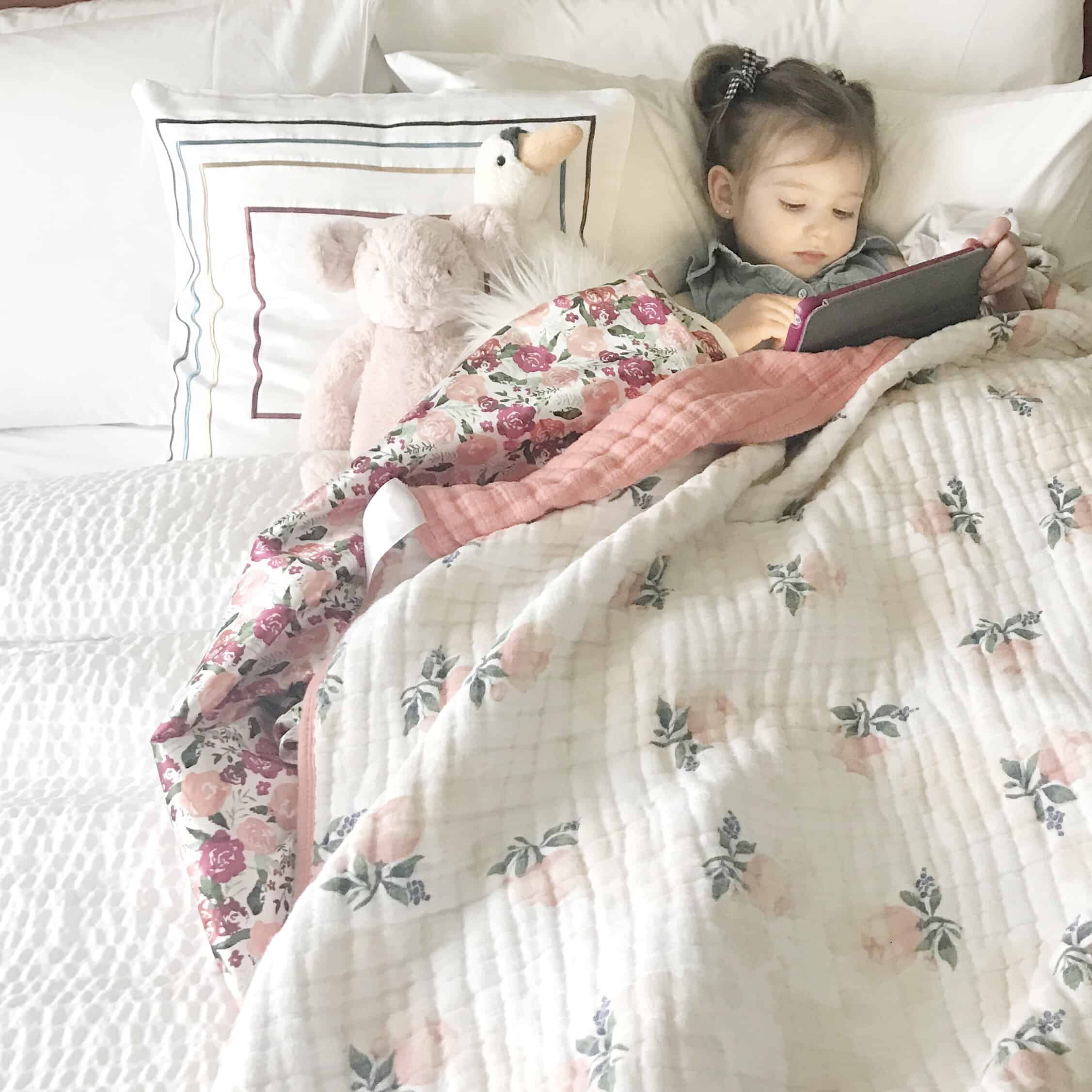 little girl lounging in hotel bed