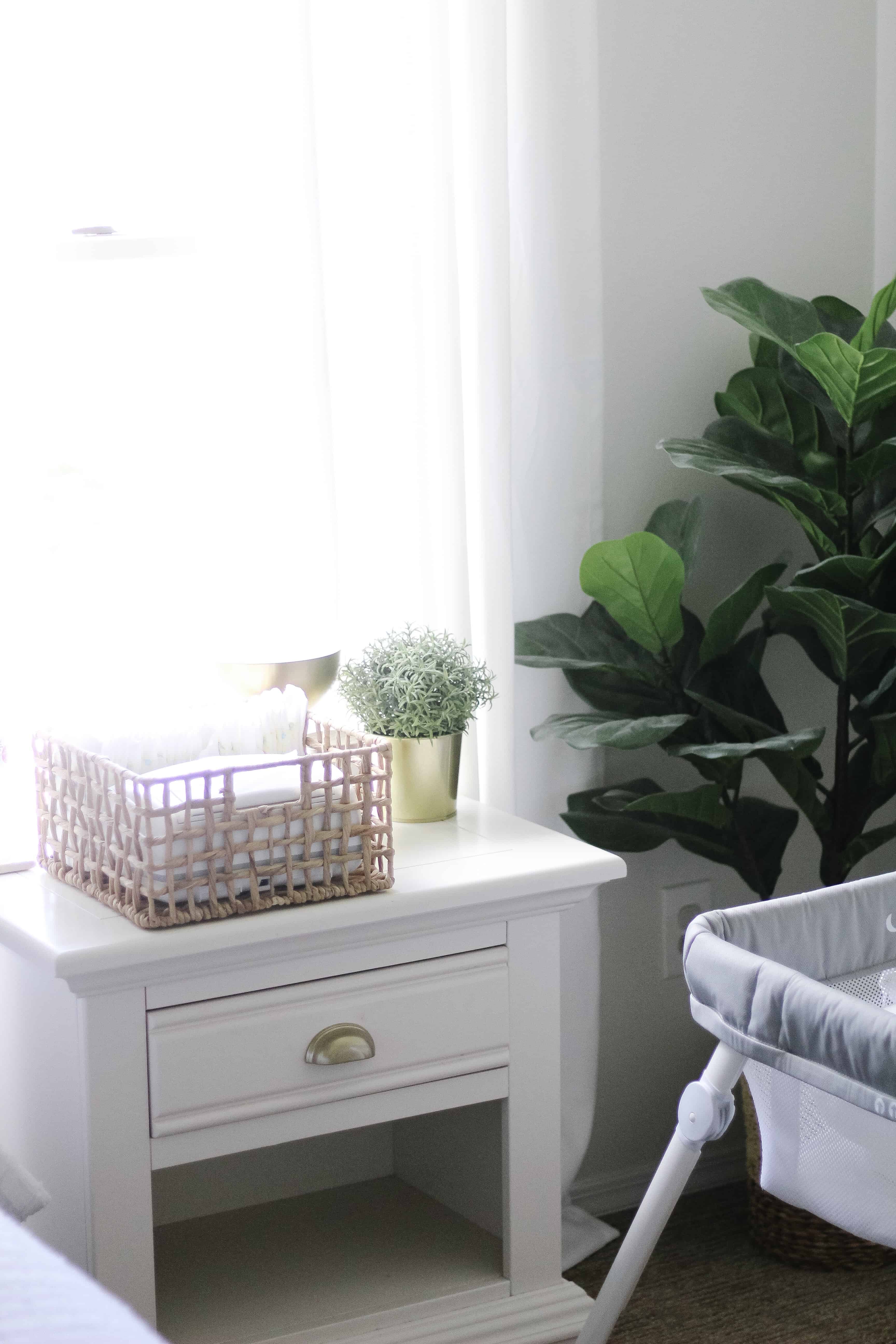 Master bedroom nightstand with basket full of diapers and wipes