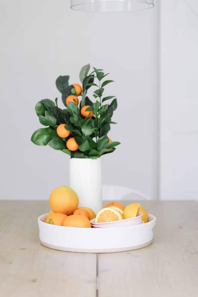 white platter with oranges and orange stems