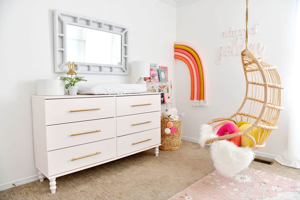 Nursery with rainbow on wall and pink Ikea dresser