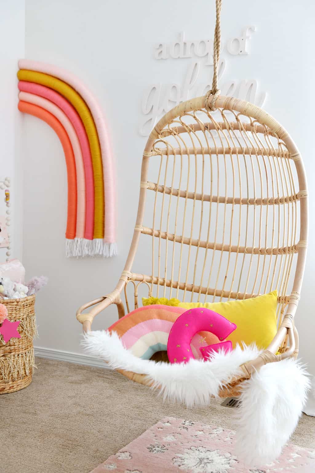 Serena and Lily rattan hanging chair with rainbow decor in Rainbow Nursery