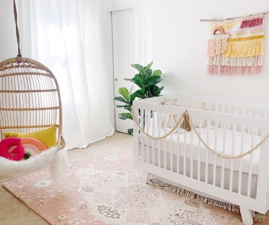 Nursery with pink rug and hanging Serena and lily chair