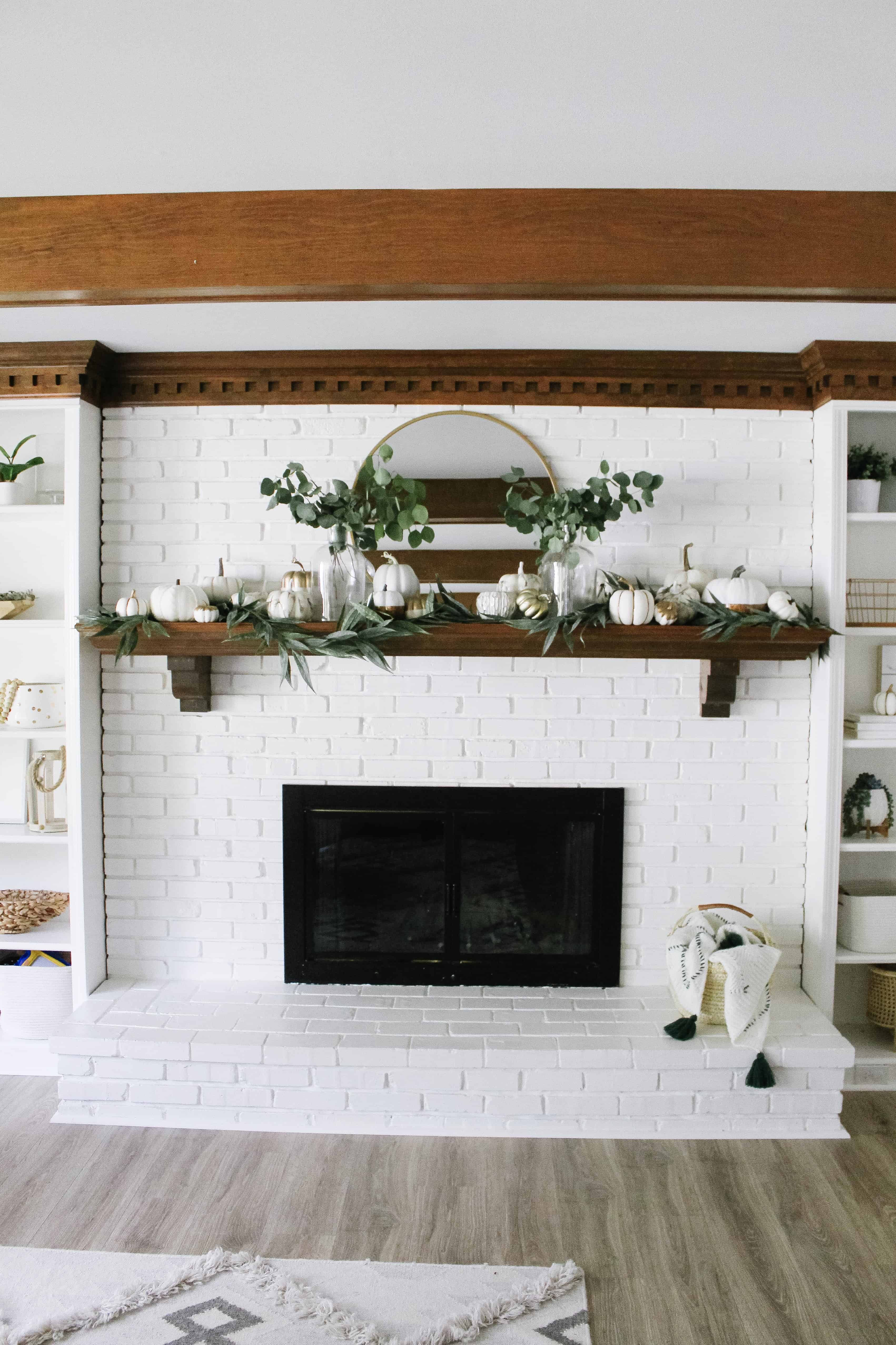 white brick mantle with neutral pumpkins 