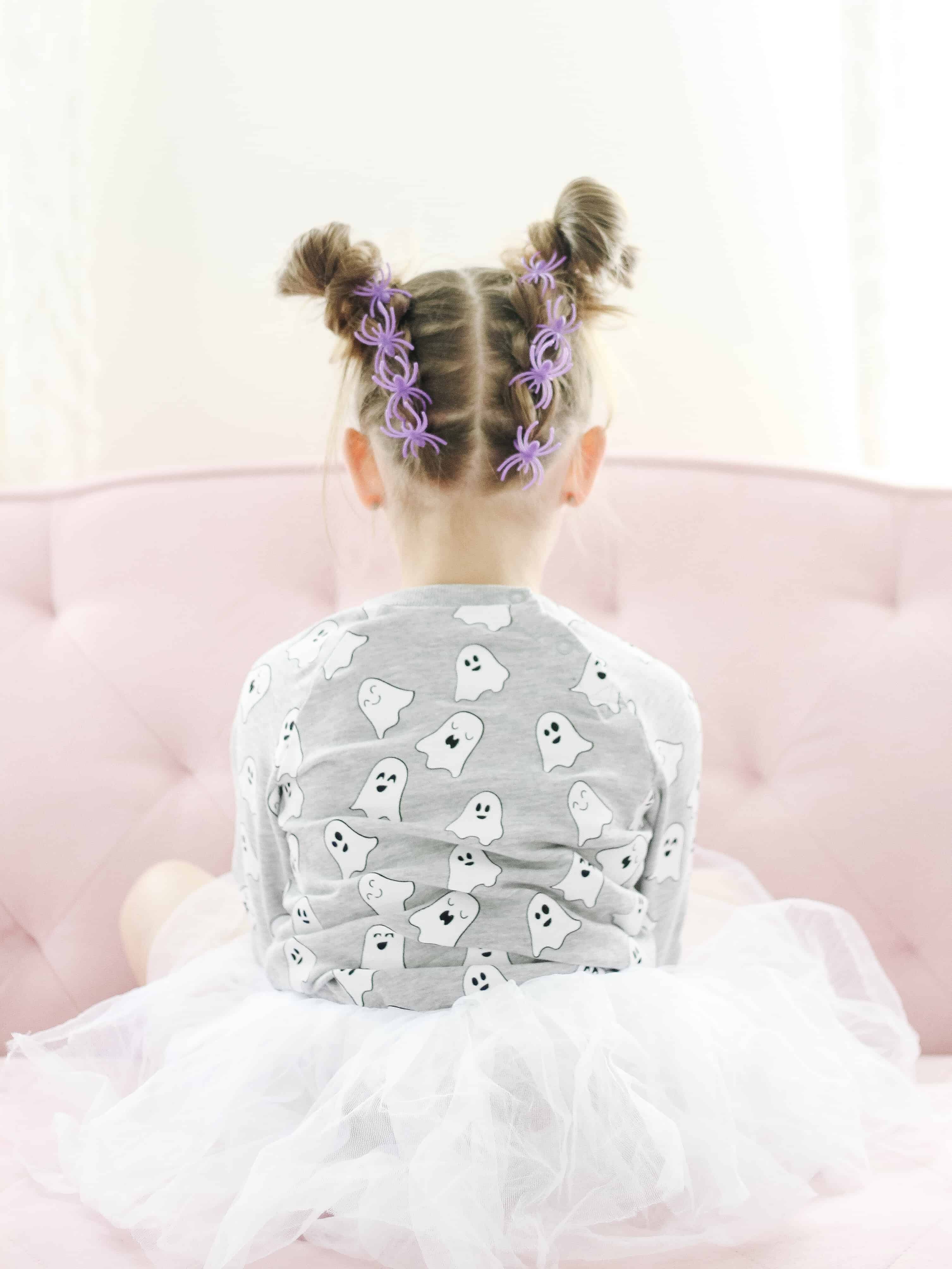 Toddler with spider rings in her hair for halloween hair